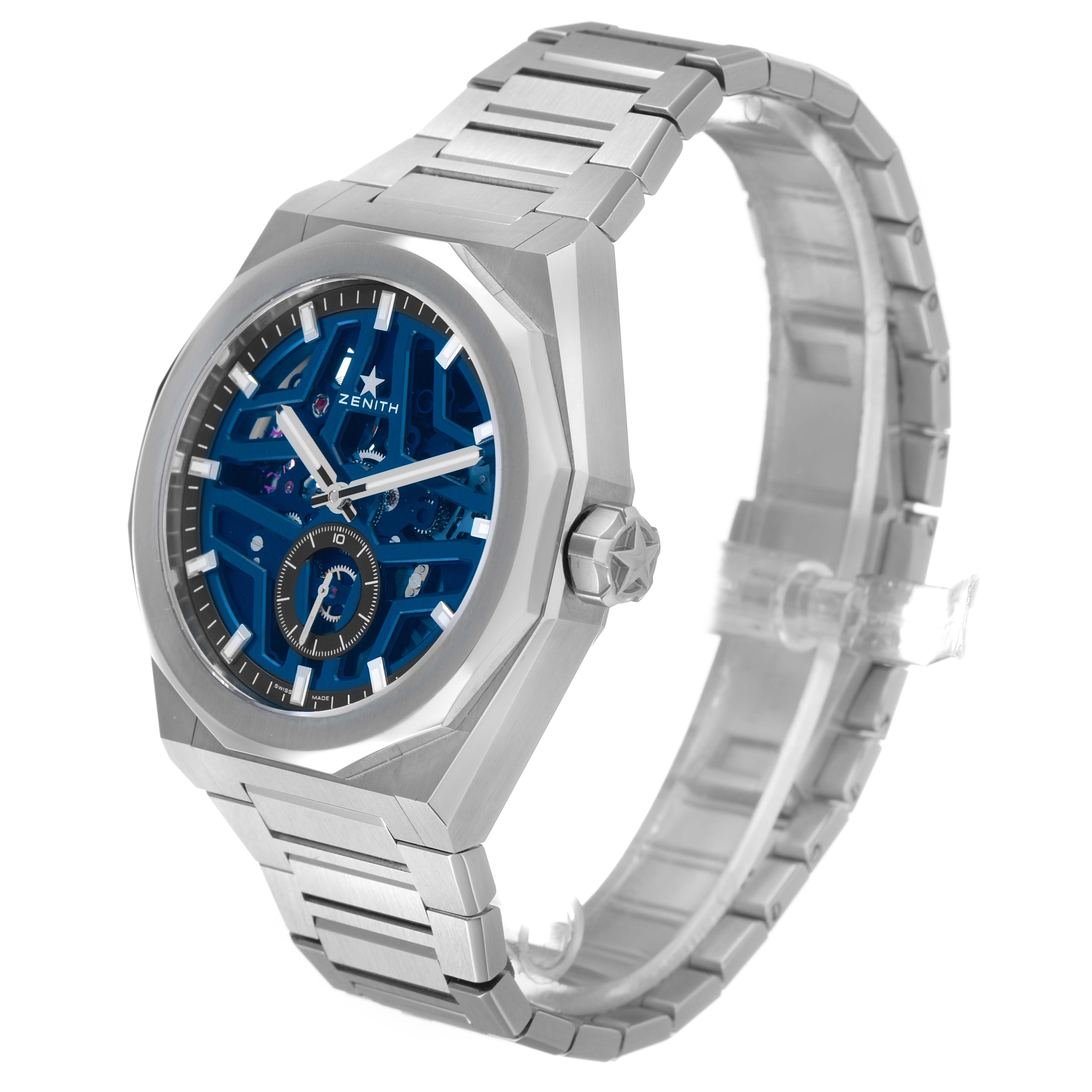 The Zenith Defy 03.9300.3620 / 79.I001 Men's Stainless Steel Blue Dial watch is shown at an angled side view, highlighting its blue openwork dial, silver case, and metal bracelet.