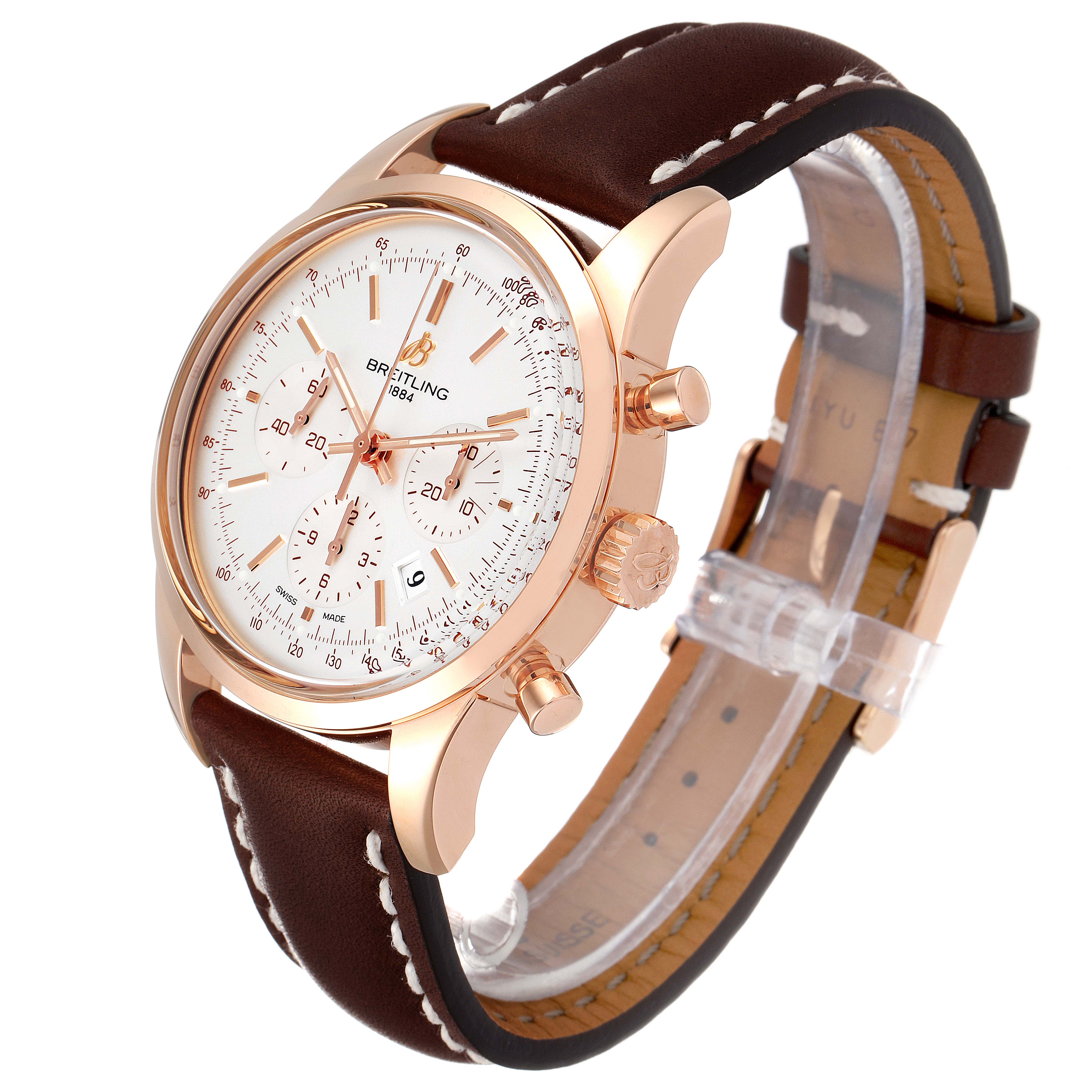 The Breitling Transocean RB0152 Men's Rose Gold Silver Dial RB0152 Men's Rose Gold Silver Dial watch is shown at an angle showcasing the dial, case, crown, pushers, and leather strap.