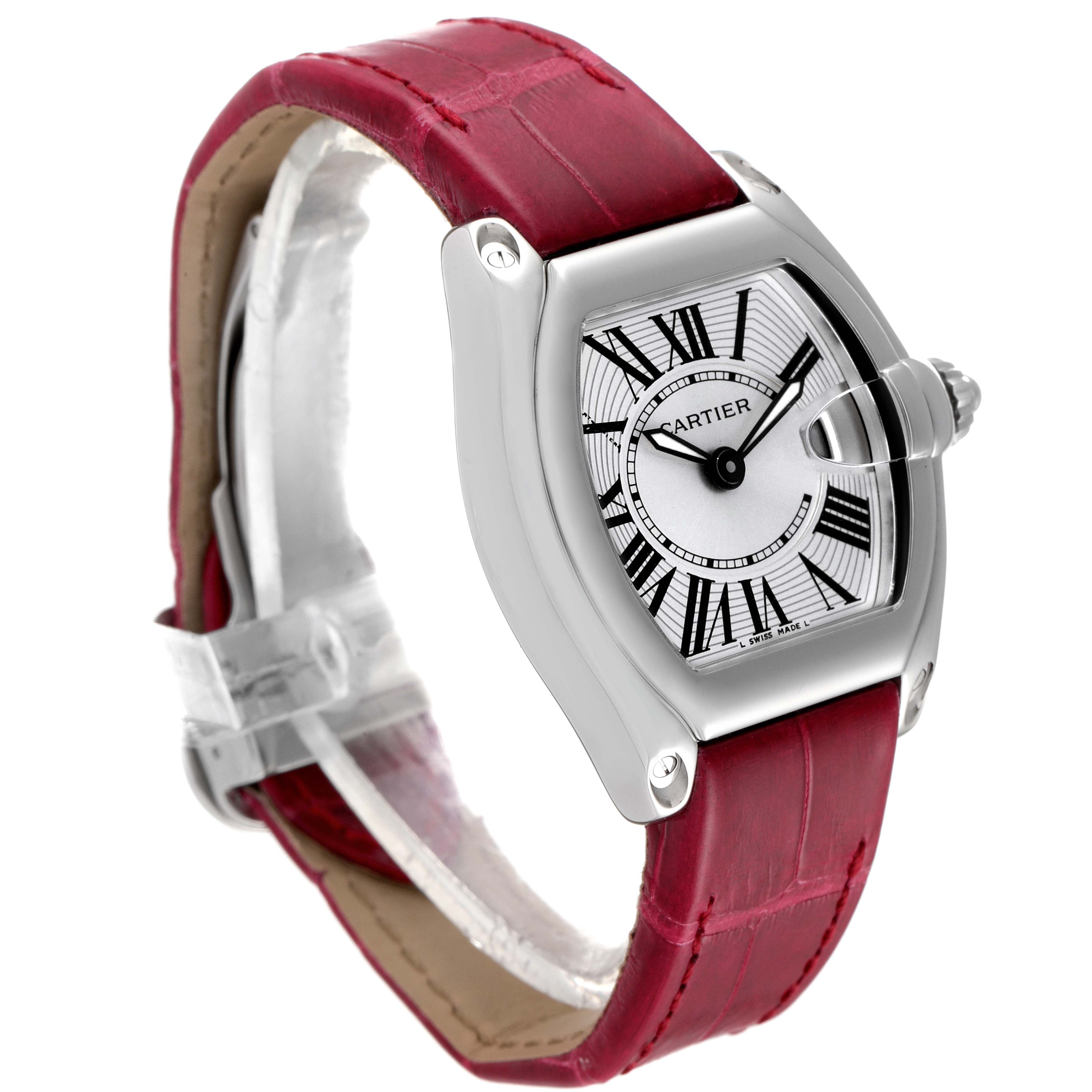This Roadster model by Cartier is shown in a side angle, displaying its silver case, white dial with Roman numerals, and red leather strap.