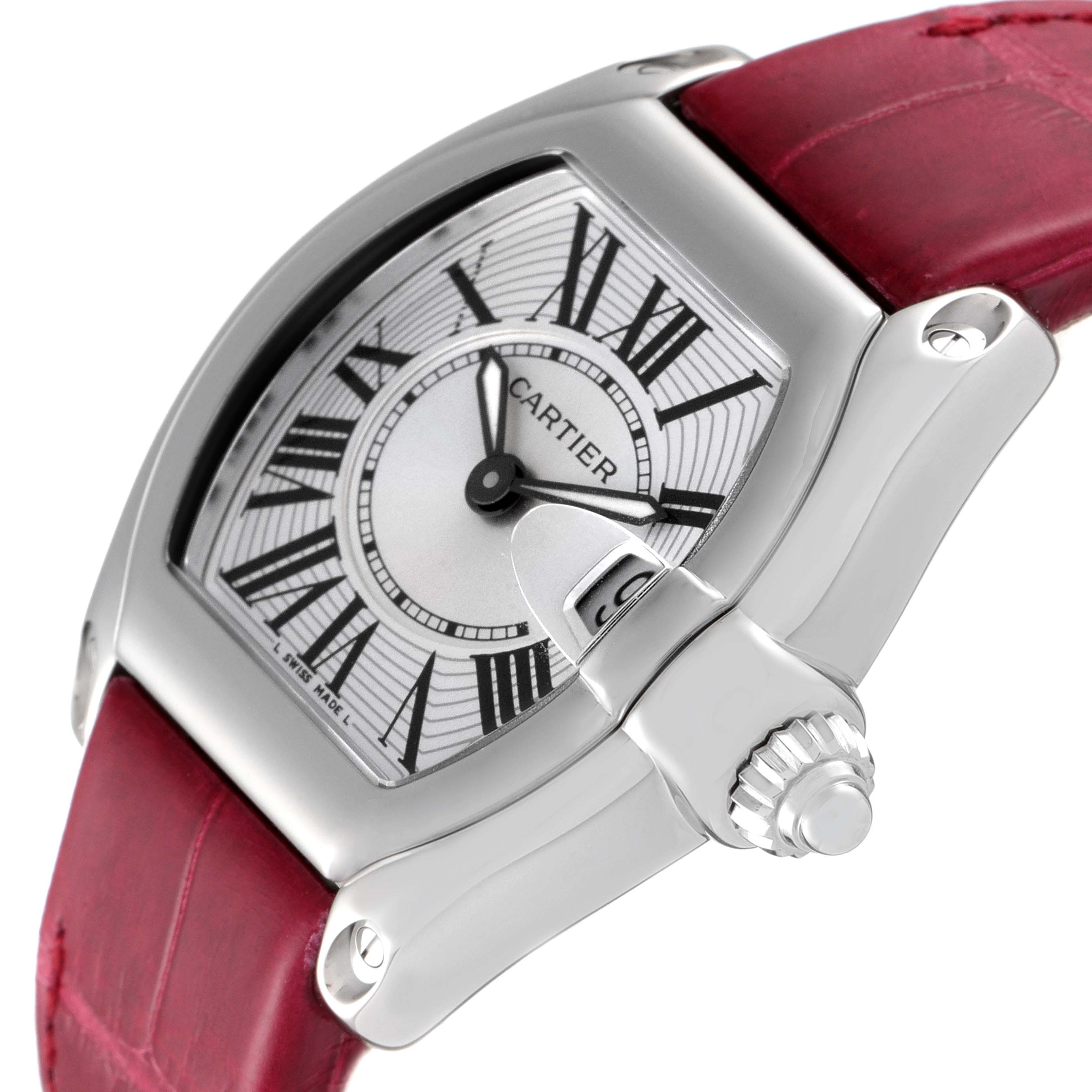 This image shows a Cartier Roadster W62016V3 Women's Stainless Steel Silver Dial W62016V3 Women's Stainless Steel Silver Dial watch at an angle highlighting the dial, crown, and part of the red leather strap.