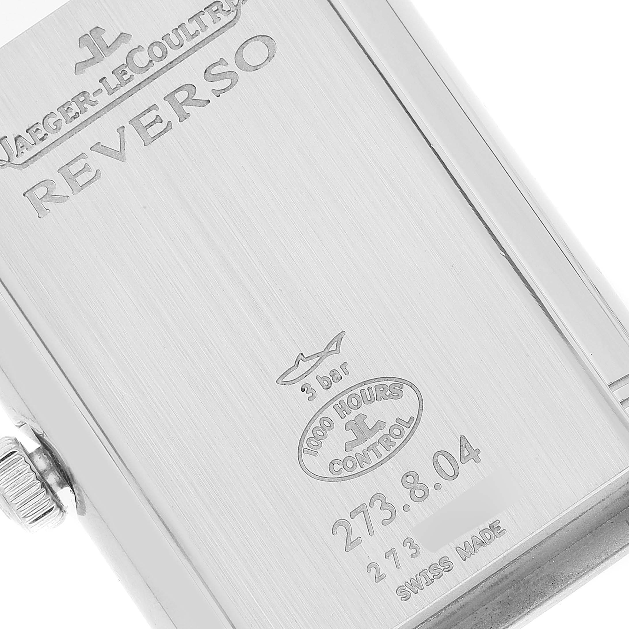 The image shows the back case of a Jaeger-LeCoultre Reverso watch, highlighting engravings and details.