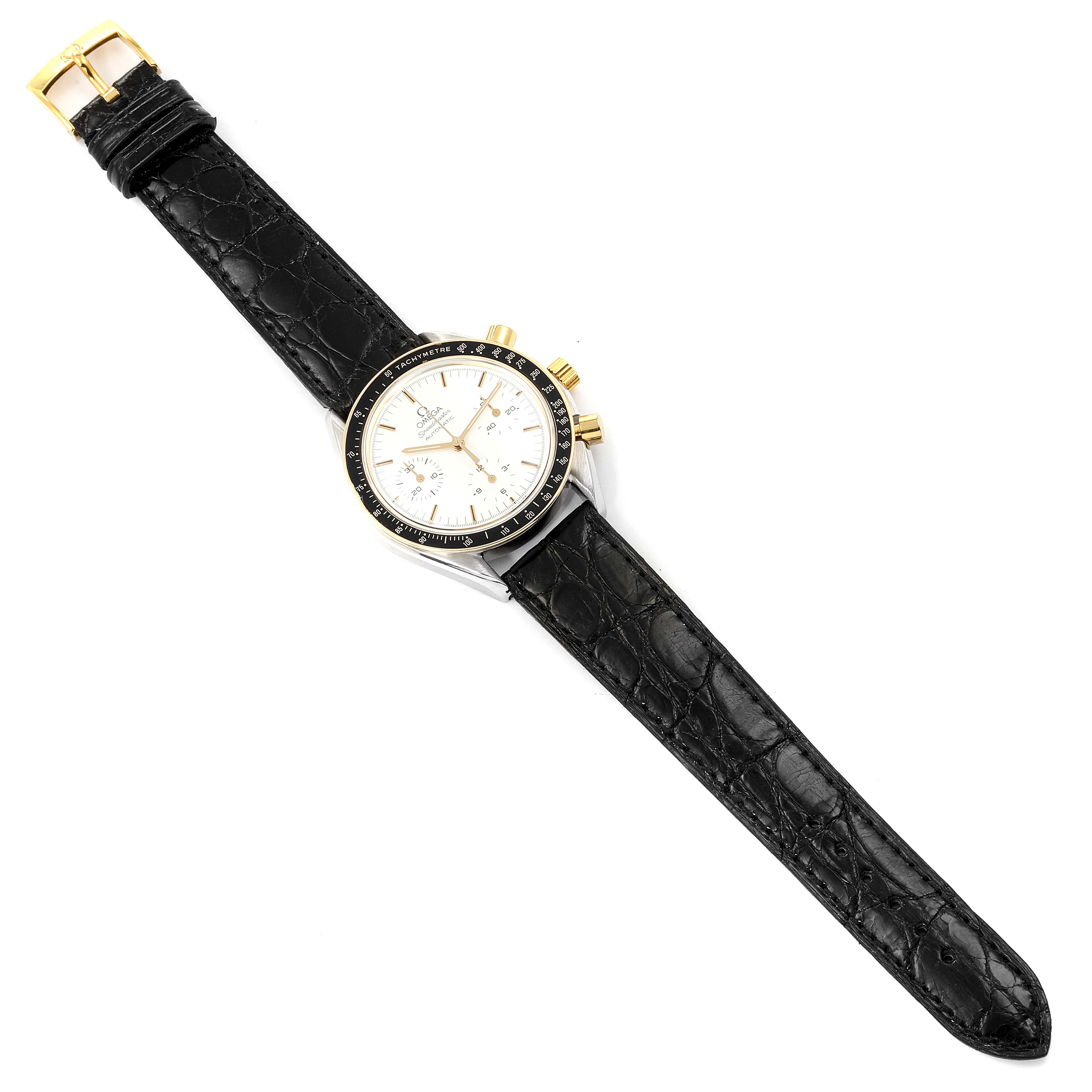 The Omega Speedmaster 3310.20.00 Men's Steel and Gold (two tone) White Dial 3310.20.00 Men's Steel and Gold (two tone) White Dial watch is shown from a top-down angle, highlighting its black leather strap and gold-toned bezel and buttons.