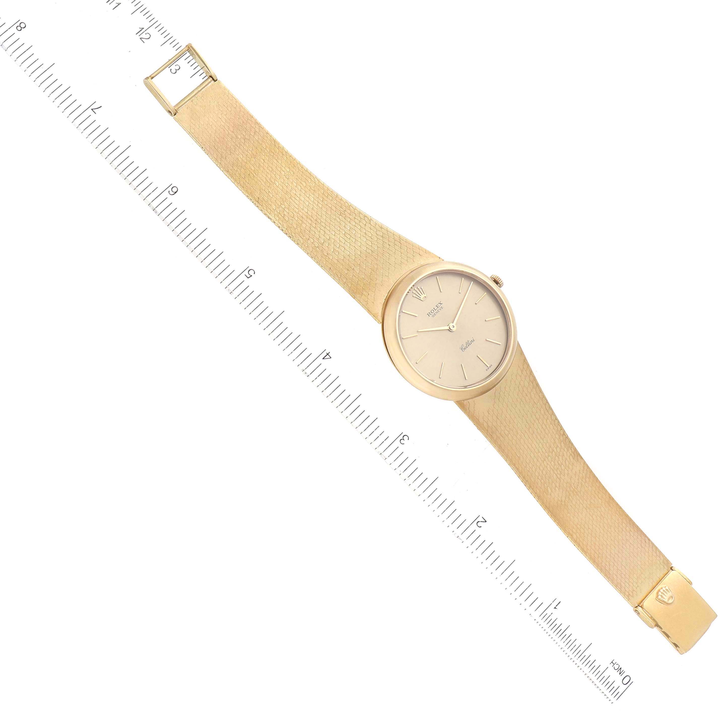 The Rolex Cellini 653 Women's Yellow Gold Champagne Dial 653 Women's Yellow Gold Champagne Dial watch is shown from a top-down angle, displaying its face, strap, and clasp alongside a ruler for size reference.