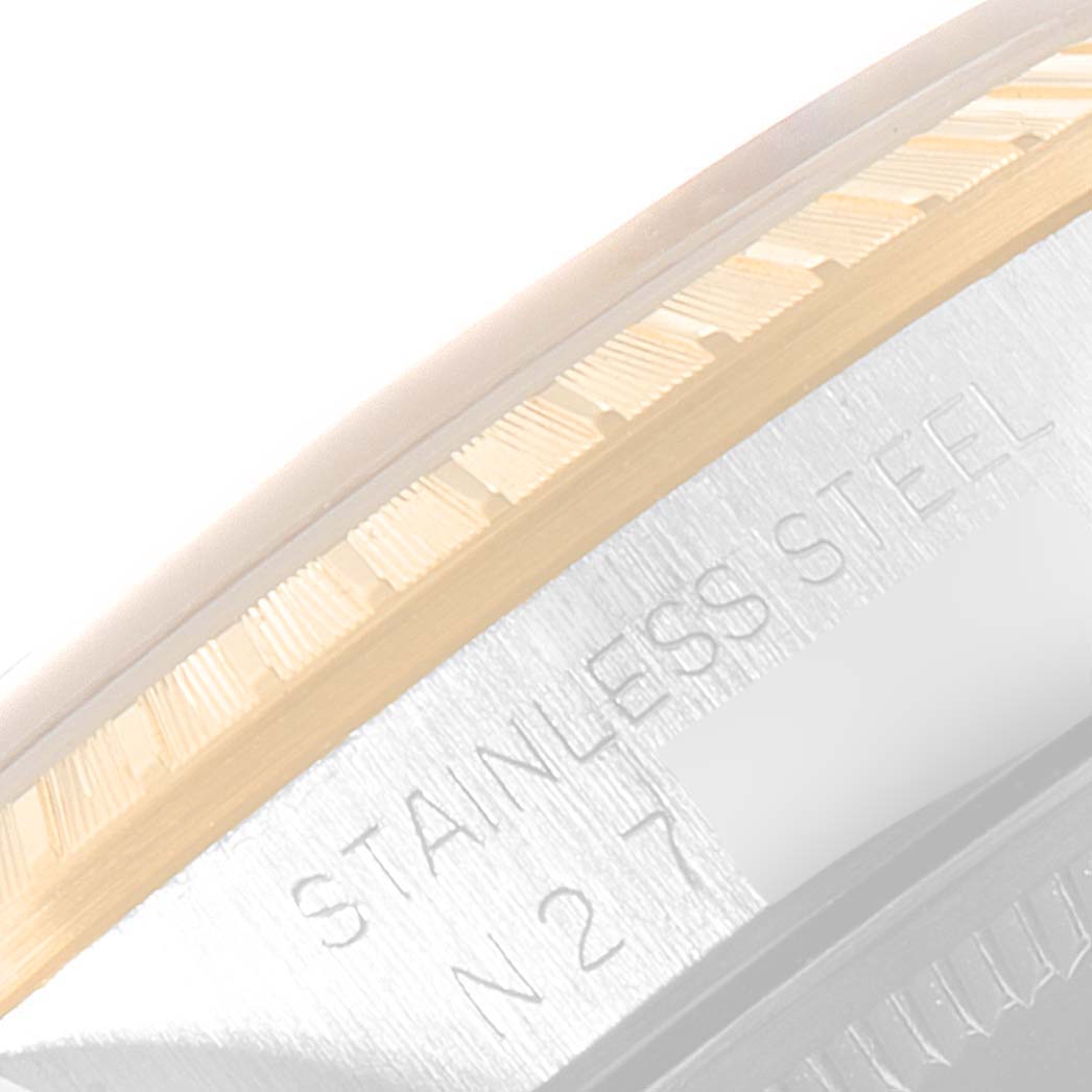 The image shows a close-up of the side of a Rolex Date 15223 Men's Steel and Gold (two tone) Champagne Dial 15223 Men's Steel and Gold (two tone) Champagne Dial model watch, focusing on the bezel and part of the stainless steel casing.