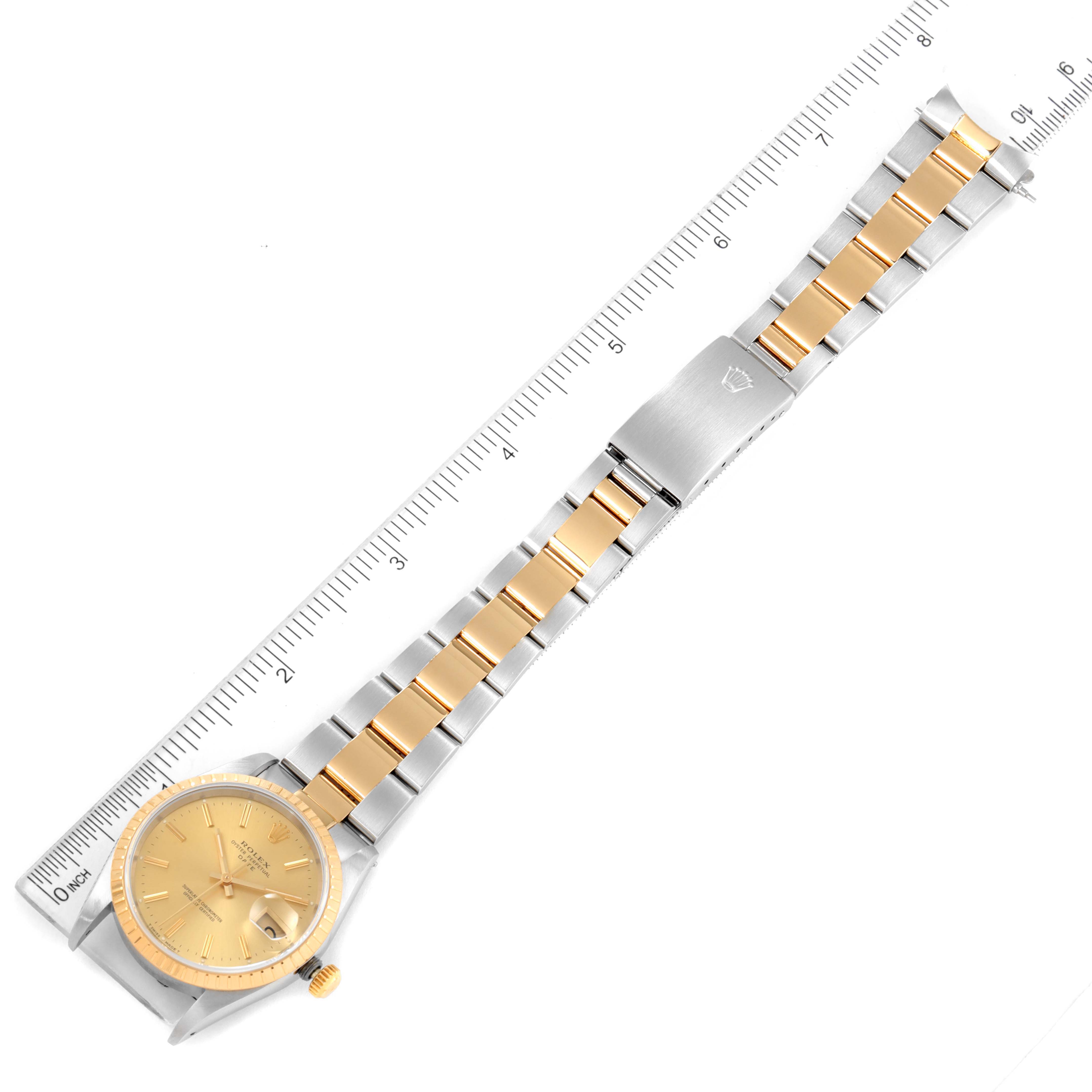 This image shows a Rolex Date 15223 Men's Steel and Gold (two tone) Champagne Dial 15223 Men's Steel and Gold (two tone) Champagne Dial model watch laid flat against a ruler, displaying the face, dial, and bracelet with clasp.