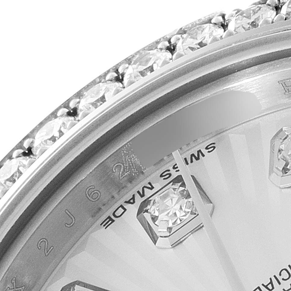 This close-up of a Rolex Datejust 179384 Women's Stainless Steel Silver Dial 179384 Women's Stainless Steel Silver Dial watch shows the diamond-studded bezel, a part of the dial, and the "Swiss Made" marking.