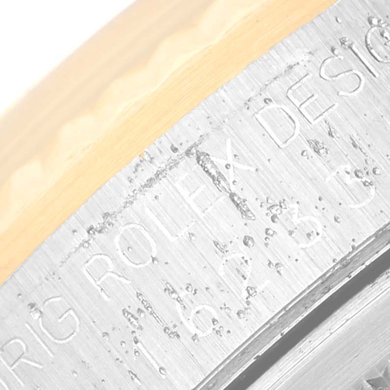 This image shows a close-up view of the engraved side of a Rolex Datejust 16233 Men's Steel and Gold (two tone) Black Dial 16233 Men's Steel and Gold (two tone) Black Dial watch bezel.