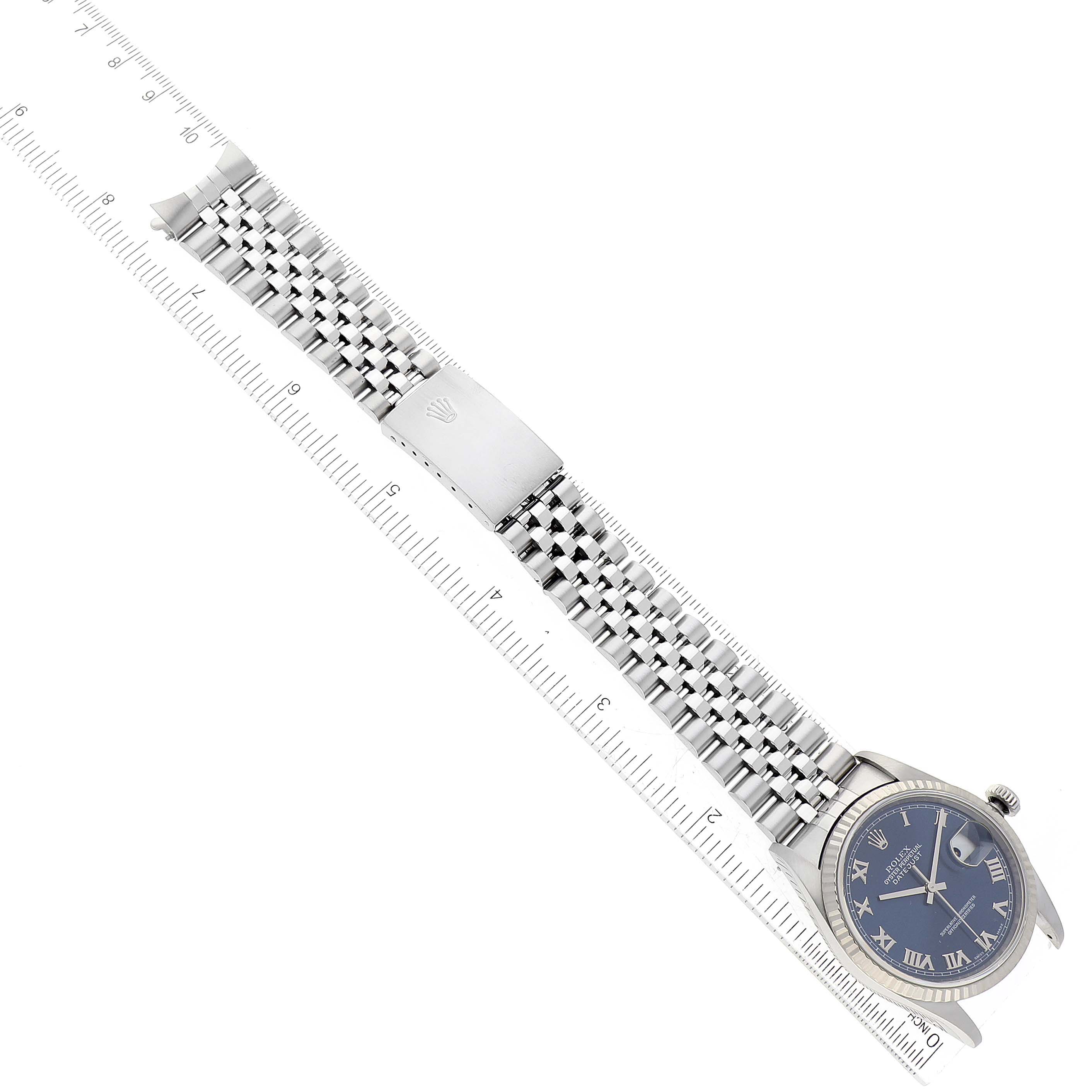The image shows a top view of a Rolex Datejust 16234 Men's Stainless Steel Blue Dial 16234 Men's Stainless Steel Blue Dial watch with the face, bracelet, and clasp visible, placed next to a ruler.