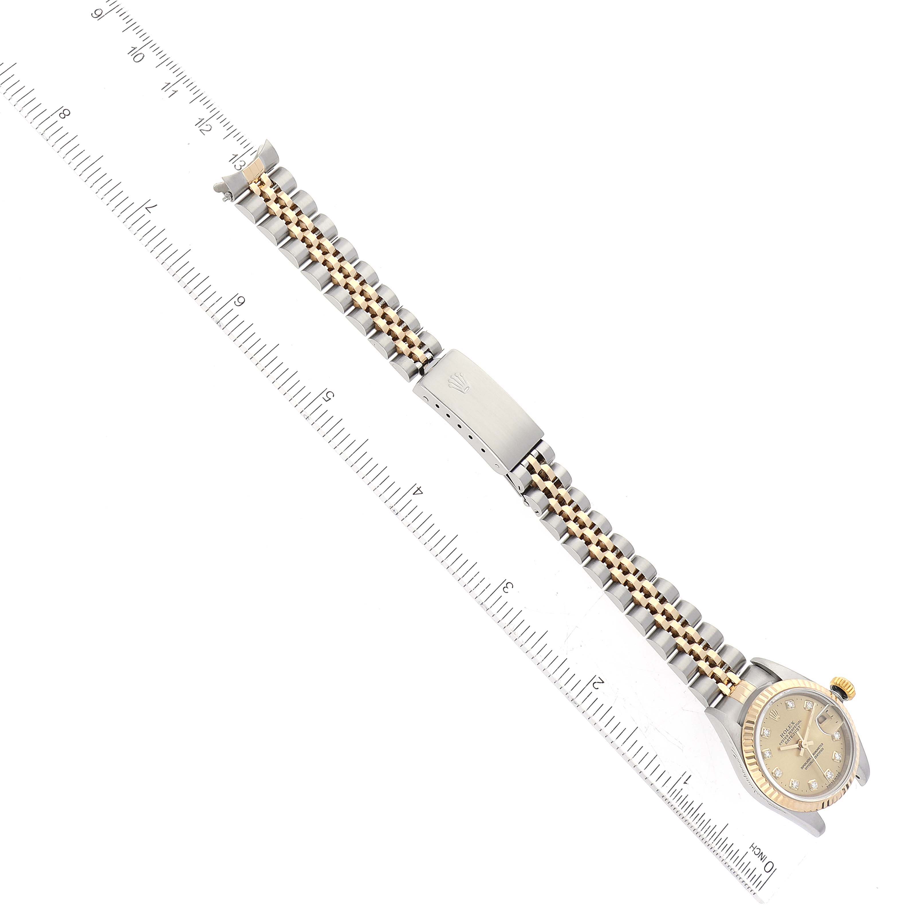 This image shows a Rolex Datejust 69173 Women's Steel and Gold (two tone) Champagne Dial 69173 Women's Steel and Gold (two tone) Champagne Dial watch from an overhead angle, displaying the watch face, band, and clasp alongside a ruler.
