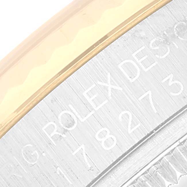 This close-up image shows the edge of the case and part of the engraving on a Rolex Mid-Size 178273 Women
s Steel and Gold (two tone) Black Dial 178273 Women
s Steel and Gold (two tone) Black Dial watch.