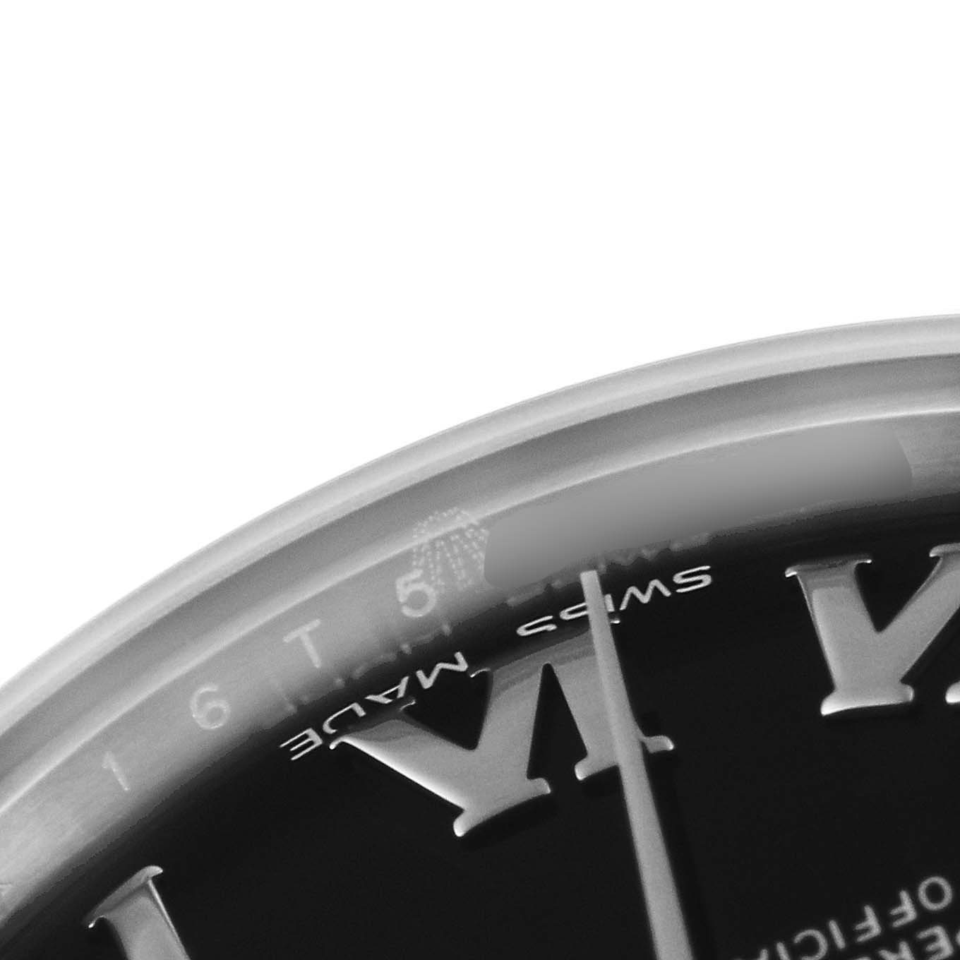 The image shows a close-up of the dial and bezel of a Mid-Size Rolex watch, highlighting the Roman numerals and part of the second hand.