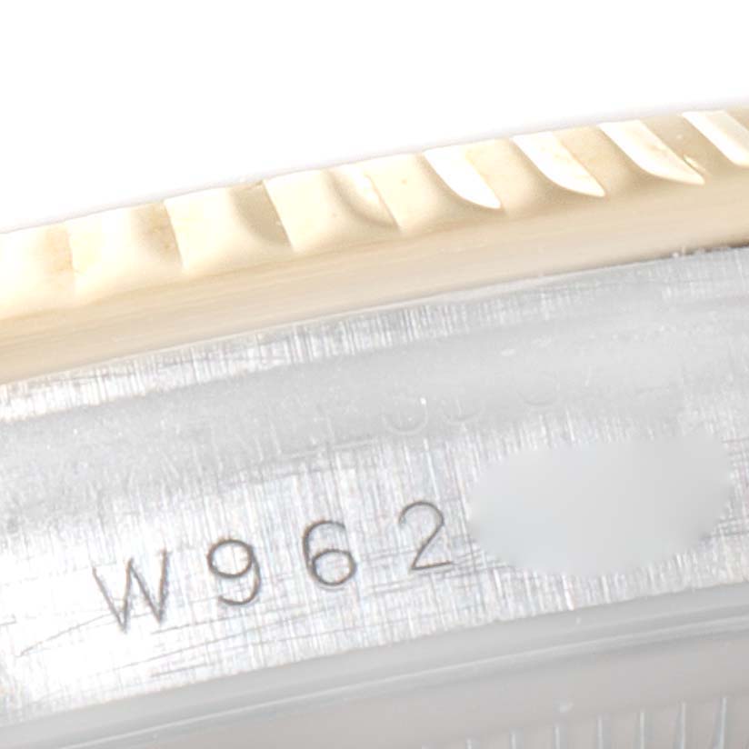 The image shows a close-up of the serial number engraving and the fluted bezel of a Rolex Datejust 16233 Men's Steel and Gold (two tone) White Dial 16233 Men's Steel and Gold (two tone) White Dial watch.
