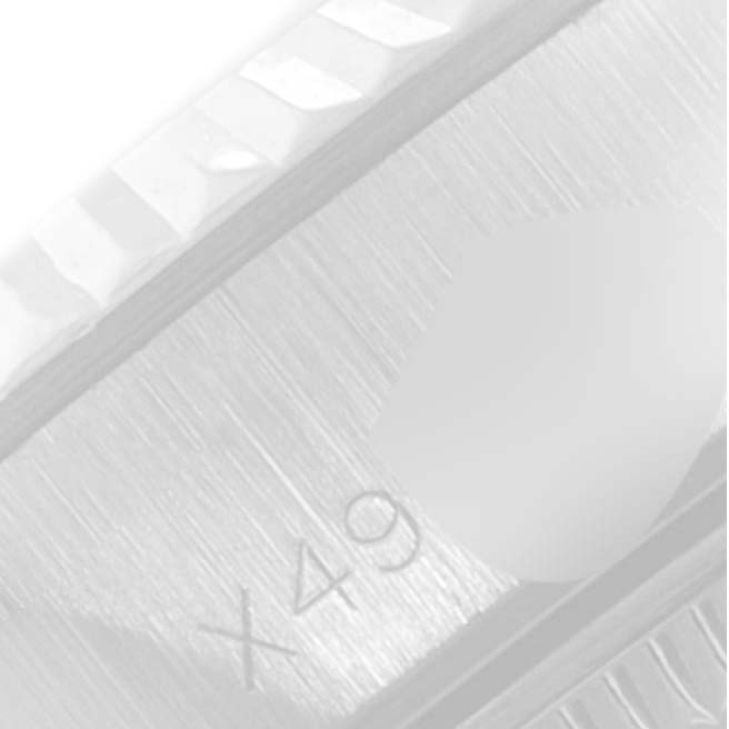 This close-up of a Rolex Datejust 69174 Women
s Stainless Steel Silver Dial 69174 Women
s Stainless Steel Silver Dial watch shows the fluted bezel and part of the dial with the "X49" engraving.