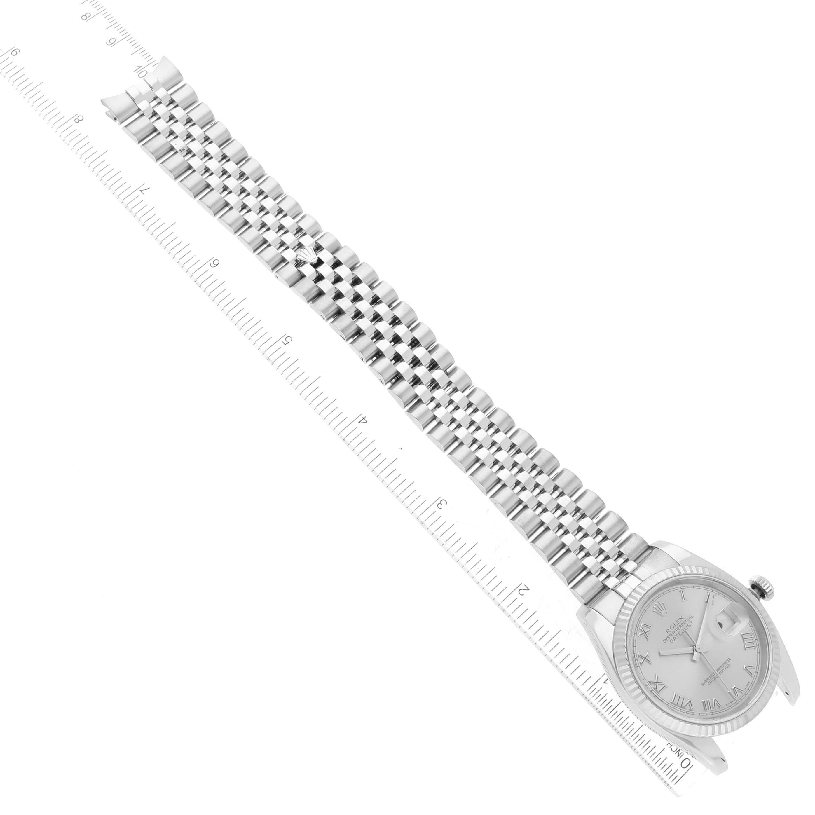 The image shows a top-down view of a Rolex Datejust 116234 Men's Stainless Steel Silver Dial 116234 Men's Stainless Steel Silver Dial watch with its silver dial and jubilee bracelet beside a ruler.