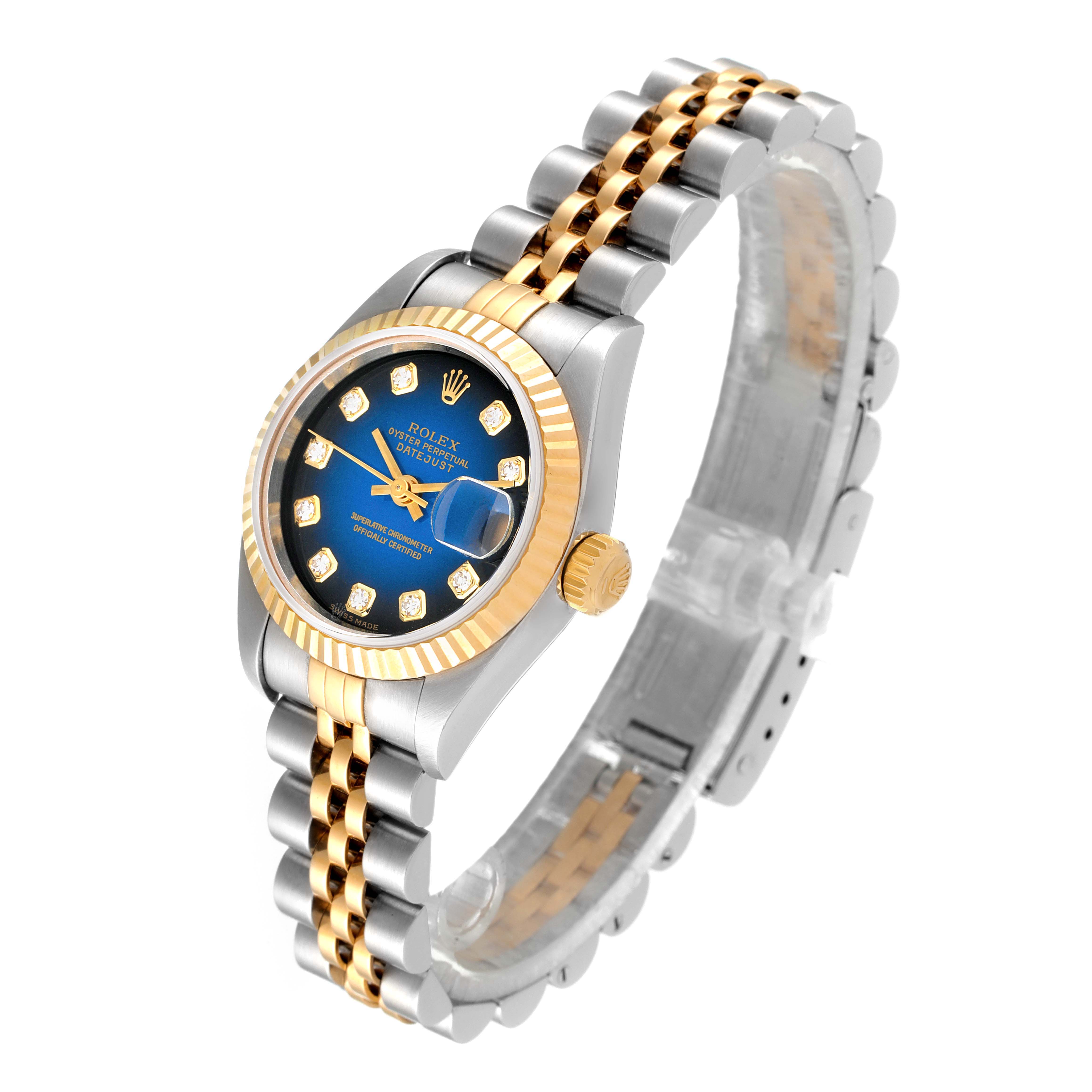 The image shows a Rolex Datejust 79173 Women's Steel and Gold (two tone) Blue Dial 79173 Women's Steel and Gold (two tone) Blue Dial watch at an angled view, highlighting its blue dial, gold fluted bezel, and two-tone bracelet.