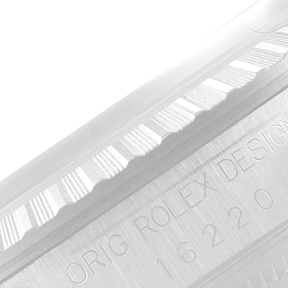 The image shows a close-up of the Rolex Datejust 16220 Men's Stainless Steel White Dial 16220 Men's Stainless Steel White Dial model's fluted bezel and engraved side indicating the model number.