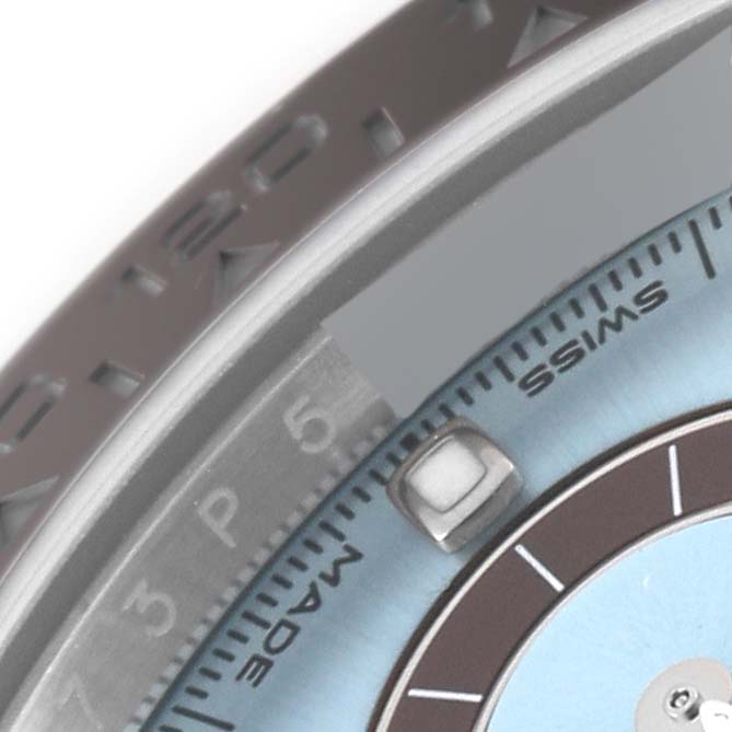 This close-up of a Rolex Daytona 116506 Men's Platinum Blue Dial 116506 Men's Platinum Blue Dial watch highlights a portion of the bezel, the Swiss-made text, and part of the dial.