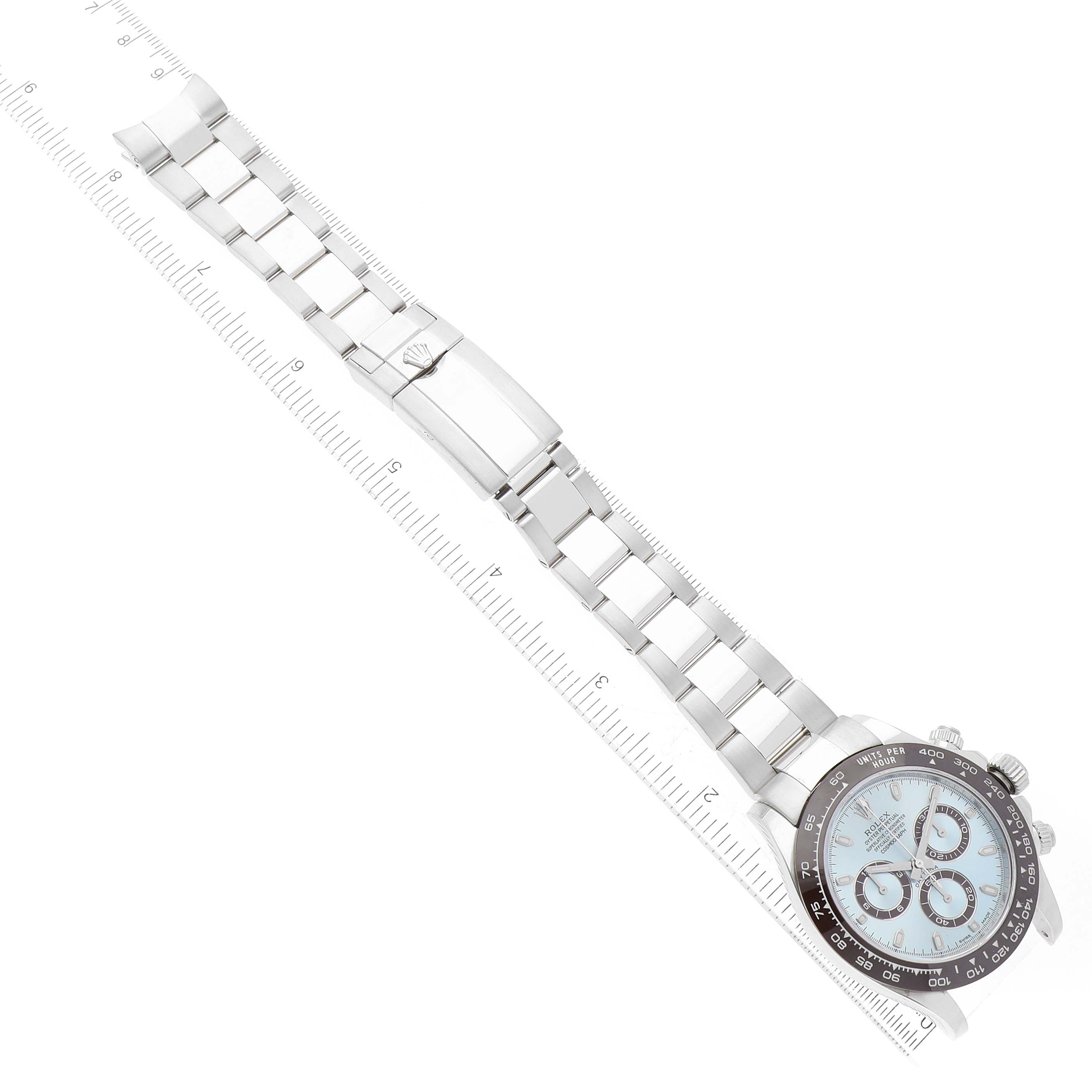 The image shows the face, bezel, and full bracelet of the Rolex Daytona 116506 Men's Platinum Blue Dial 116506 Men's Platinum Blue Dial watch laid flat with a ruler for scale.