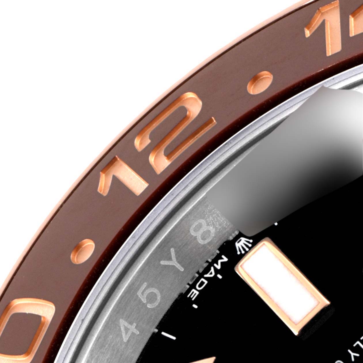 This image shows a close-up of the bezel and part of the dial of a Rolex GMT-Master 126711CHNR Men's Steel and Gold (two tone) Black Dial 126711CHNR Men's Steel and Gold (two tone) Black Dial watch.