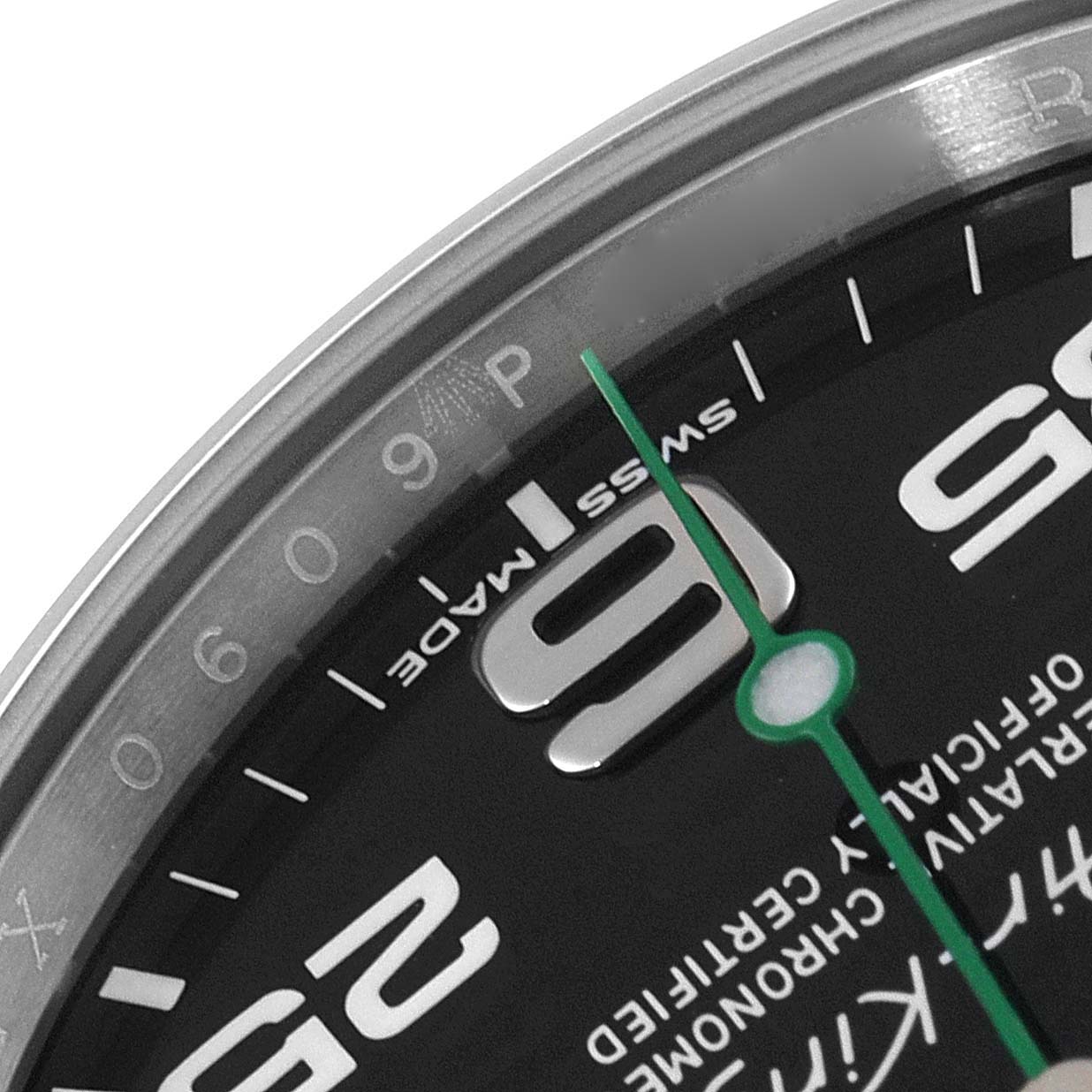 This close-up view of the Rolex Air-King 116900 Men's Stainless Steel Black Dial 116900 Men's Stainless Steel Black Dial watch shows the "Swiss Made" text, part of the "6" numeral, and a portion of the green second hand.