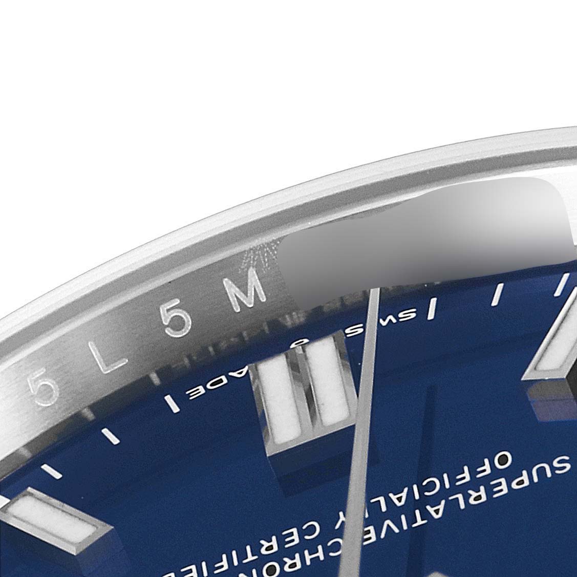 This close-up image of a Rolex Oyster Perpetual 126000 Men's Stainless Steel Blue Dial 126000 Men's Stainless Steel Blue Dial watch shows part of the blue dial, markers, and a section of the inner bezel.