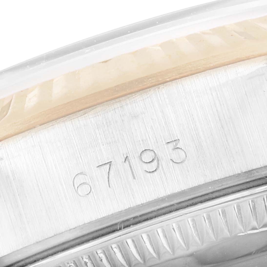 The image shows a close-up of the side of the Rolex Oyster Perpetual 67193 Women's Steel and Gold (two tone) Champagne Dial 67193 Women's Steel and Gold (two tone) Champagne Dial model, focusing on the engraved serial number.