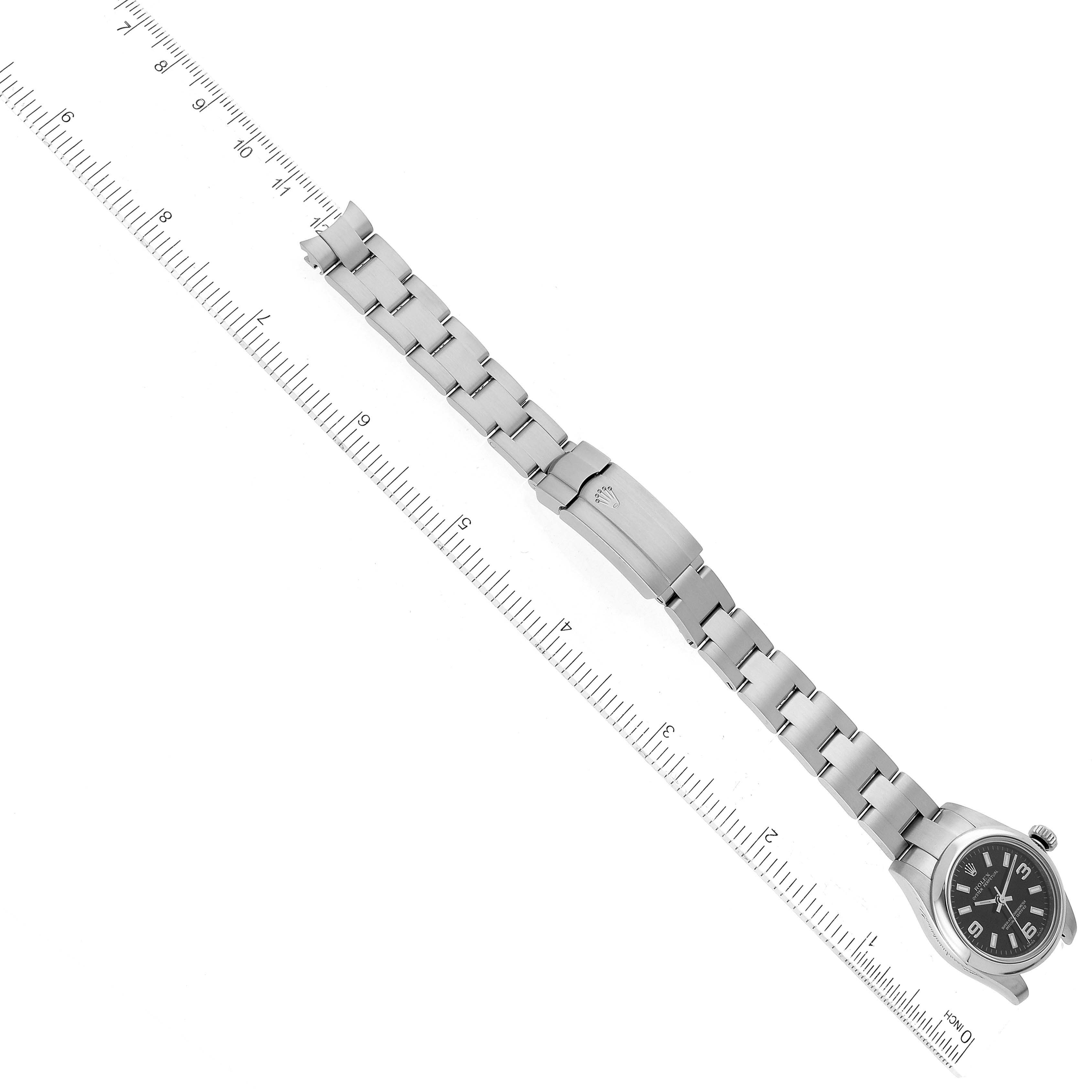 The image shows a fully extended Rolex Oyster Perpetual 176200 Women's Stainless Steel Black Dial 176200 Women's Stainless Steel Black Dial watch placed alongside a ruler for size reference.