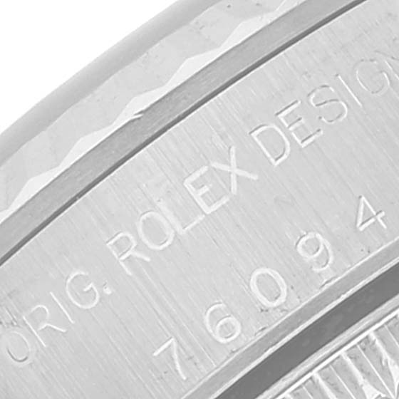 This is a close-up of the case back edge of the Rolex Oyster Perpetual 76094 Women's Stainless Steel Black Dial 76094 Women's Stainless Steel Black Dial, showing engraved text and part of the bezel.