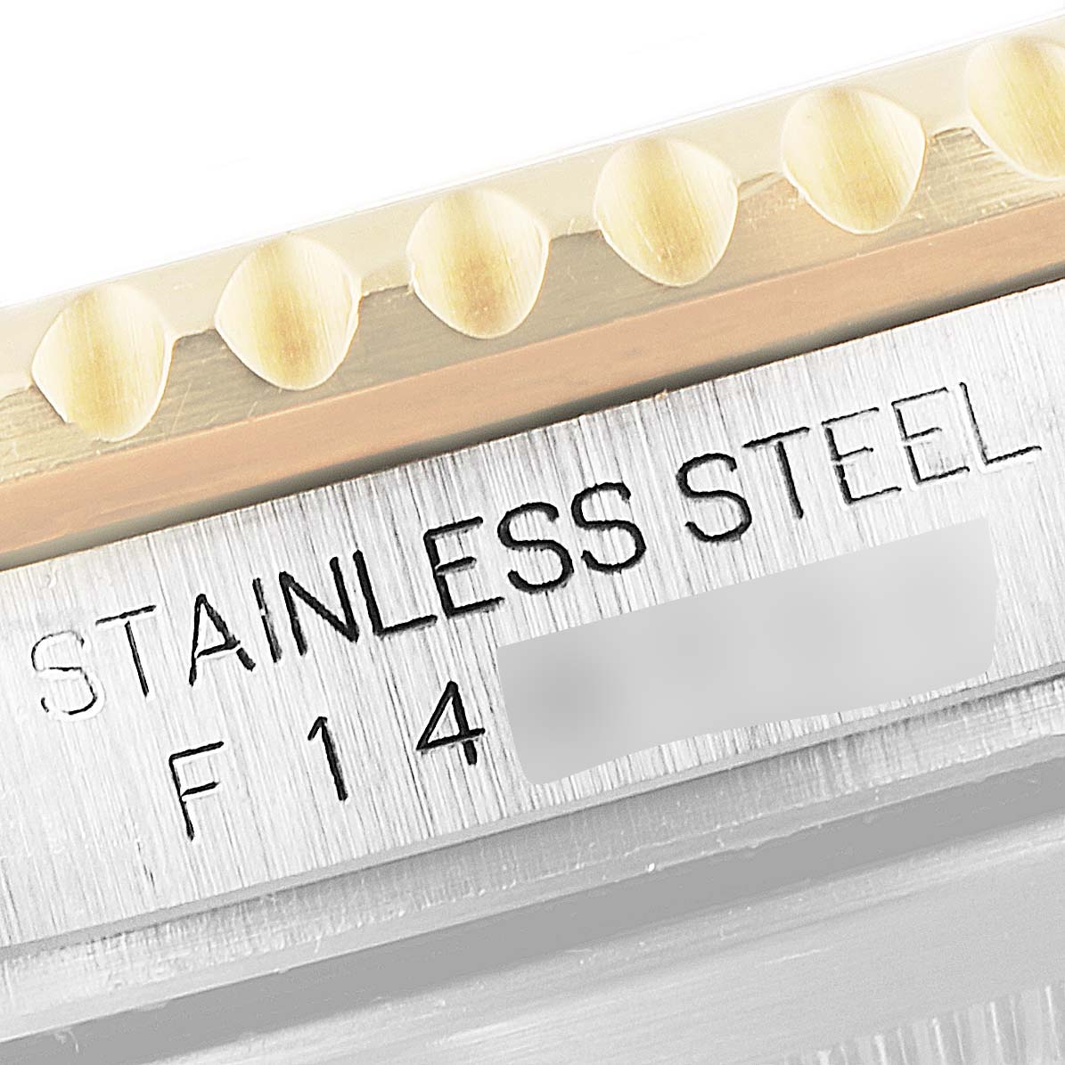 This close-up image shows the edge of the bezel and the case side with "STAINLESS STEEL" etched on a Rolex Submariner 16613 Men
s Steel and Gold (two tone) Blue Dial 16613 Men
s Steel and Gold (two tone) Blue Dial watch.