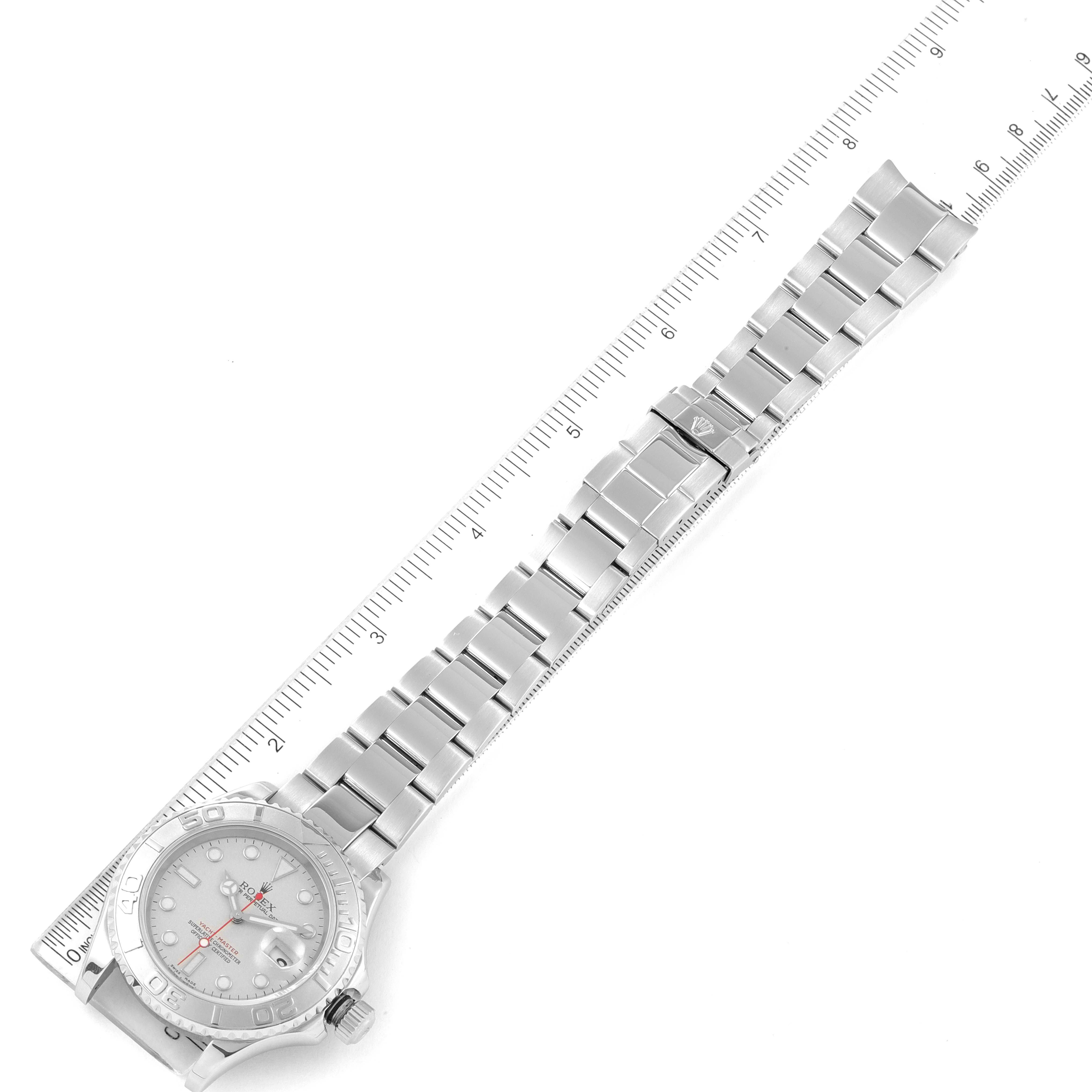 The image shows a top-down view of a Rolex Yacht-Master 16622 Men's Stainless Steel Silver Dial 16622 Men's Stainless Steel Silver Dial watch, including the face, bracelet, and clasp, alongside a measuring scale.