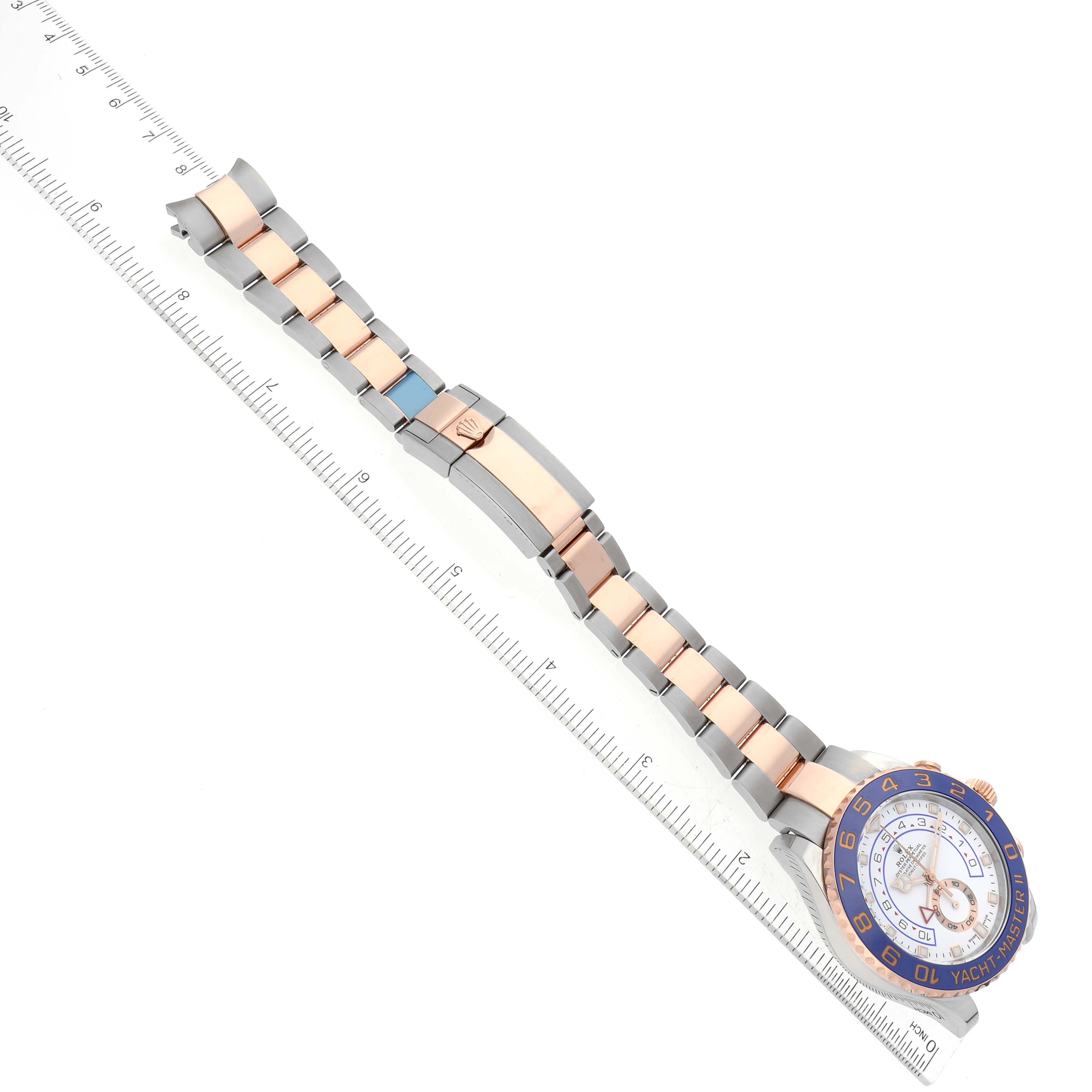 The image shows a Rolex Yacht-Master 116681 Men's Steel and Gold (two tone) White Dial 116681 Men's Steel and Gold (two tone) White Dial watch from a top-down angle, including its bracelet stretched out against a ruler for scale.