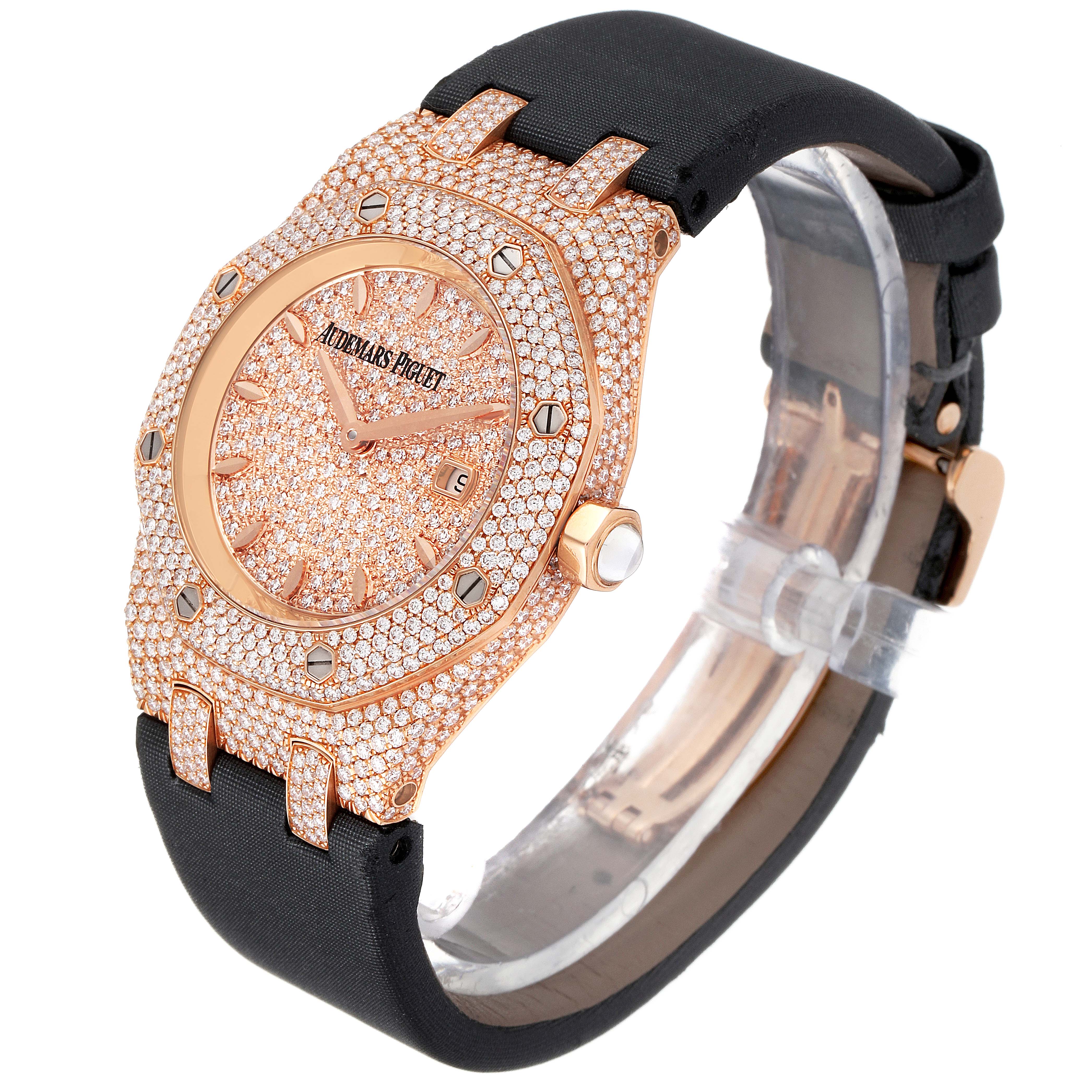 The Audemars Piguet Royal Oak 67625OR.ZZ.D009SU.01 Women's Rose Gold Pink Dial 67625OR.ZZ.D009SU.01 Women's Rose Gold Pink Dial watch is shown at an angle highlighting its diamond-encrusted face, bezel, and black strap.