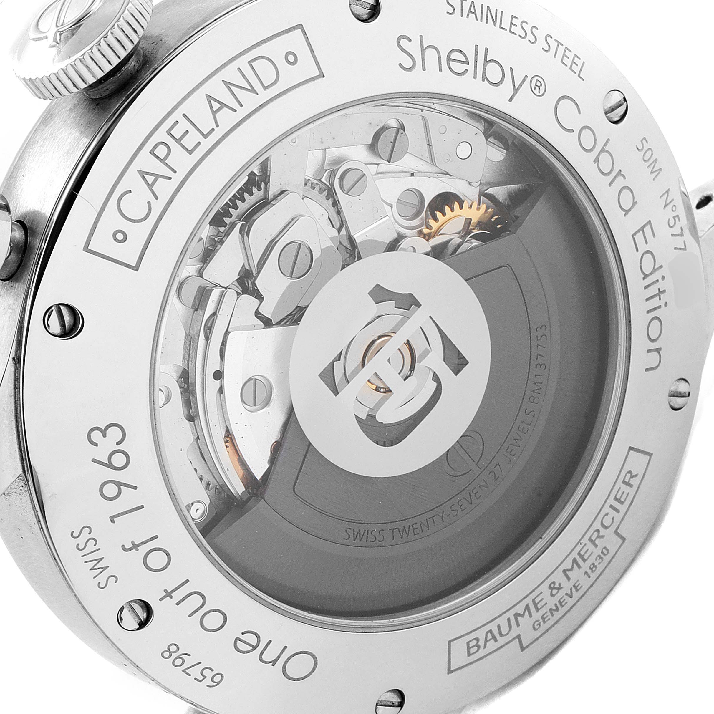 The image shows the back view of a Baume & Mercier Capeland 65798 Men's Stainless Steel Black Dial 65798 Men's Stainless Steel Black Dial Shelby® Cobra Edition watch, highlighting its internal mechanism and engravings.