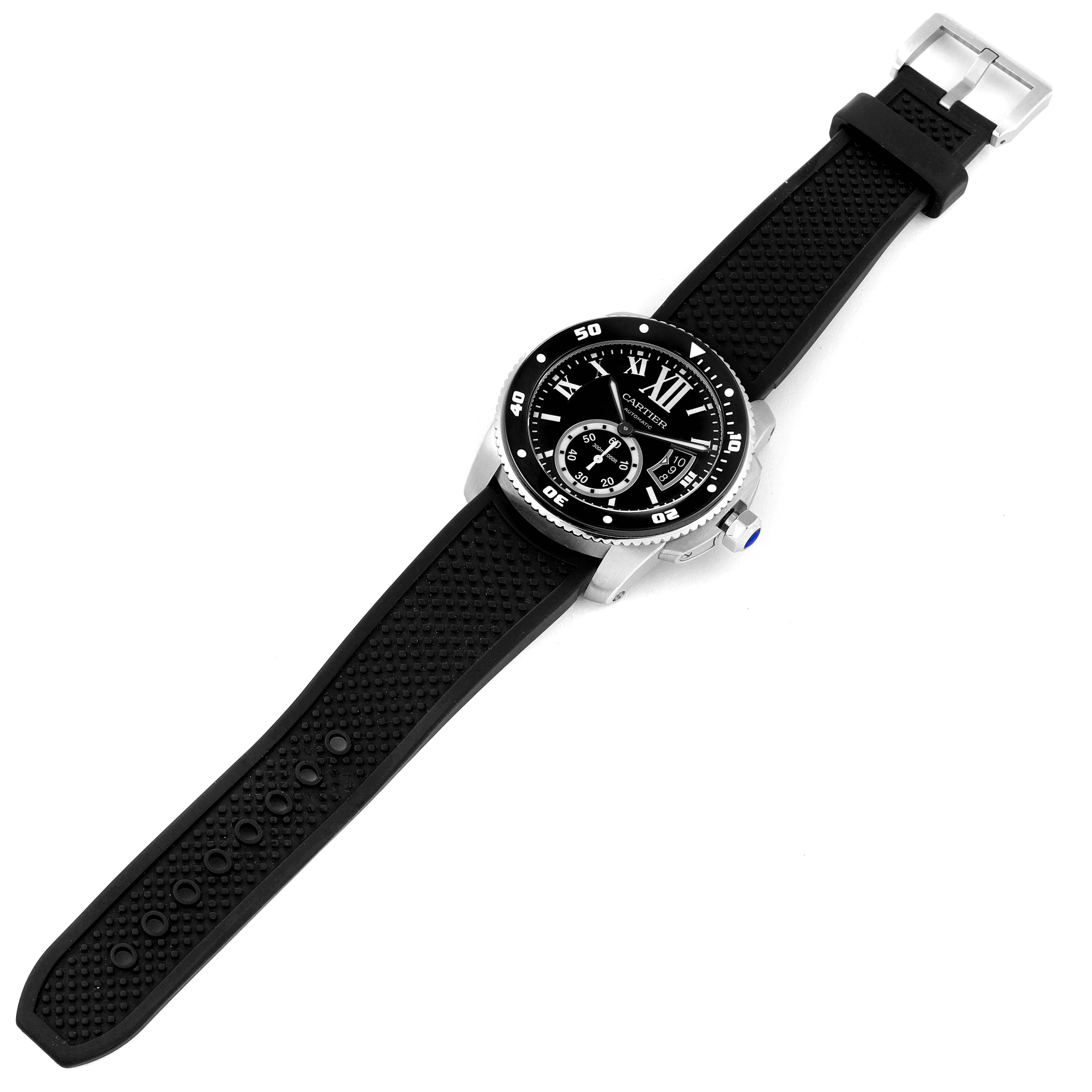 The image shows a top view of a Calibre de Cartier watch by Cartier, featuring its black dial, bezel, and black strap.