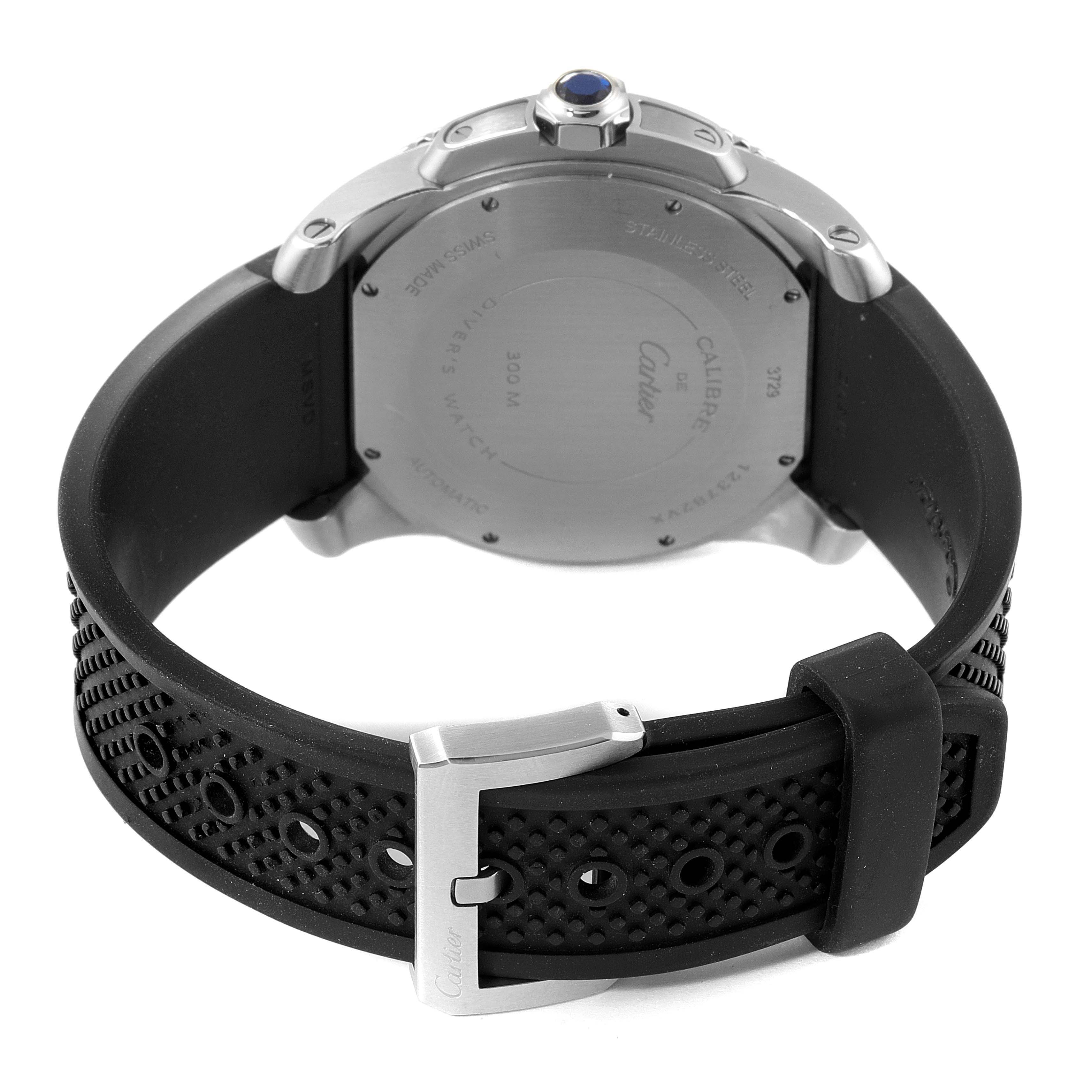 The image shows the back of the Calibre de Cartier watch by Cartier, featuring the case back and black perforated rubber strap with buckle.