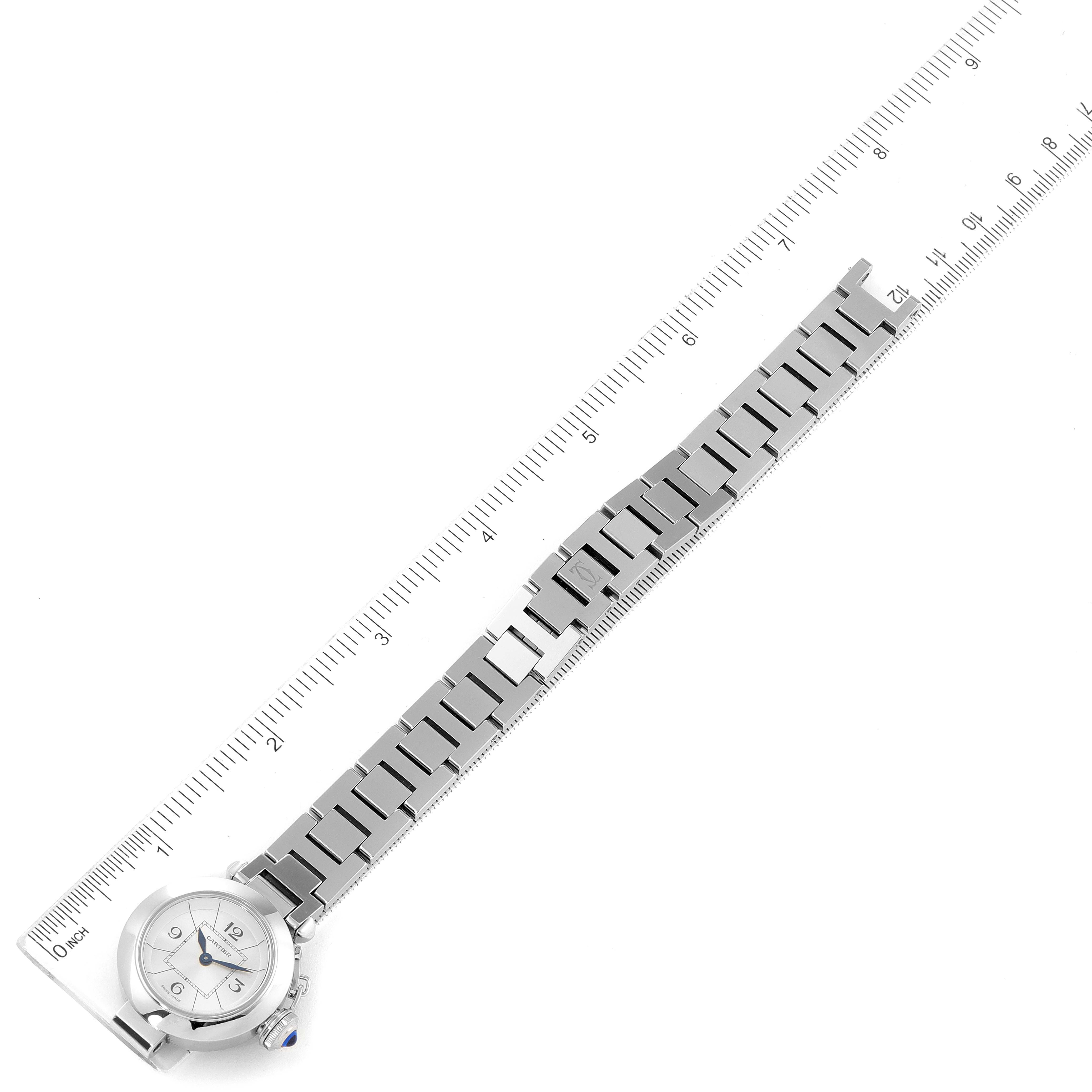 The Cartier Pasha W3140007 Women's Stainless Steel Silver Dial W3140007 Women's Stainless Steel Silver Dial watch is shown from a top view, displaying the face and entire metal bracelet laid out next to a ruler.