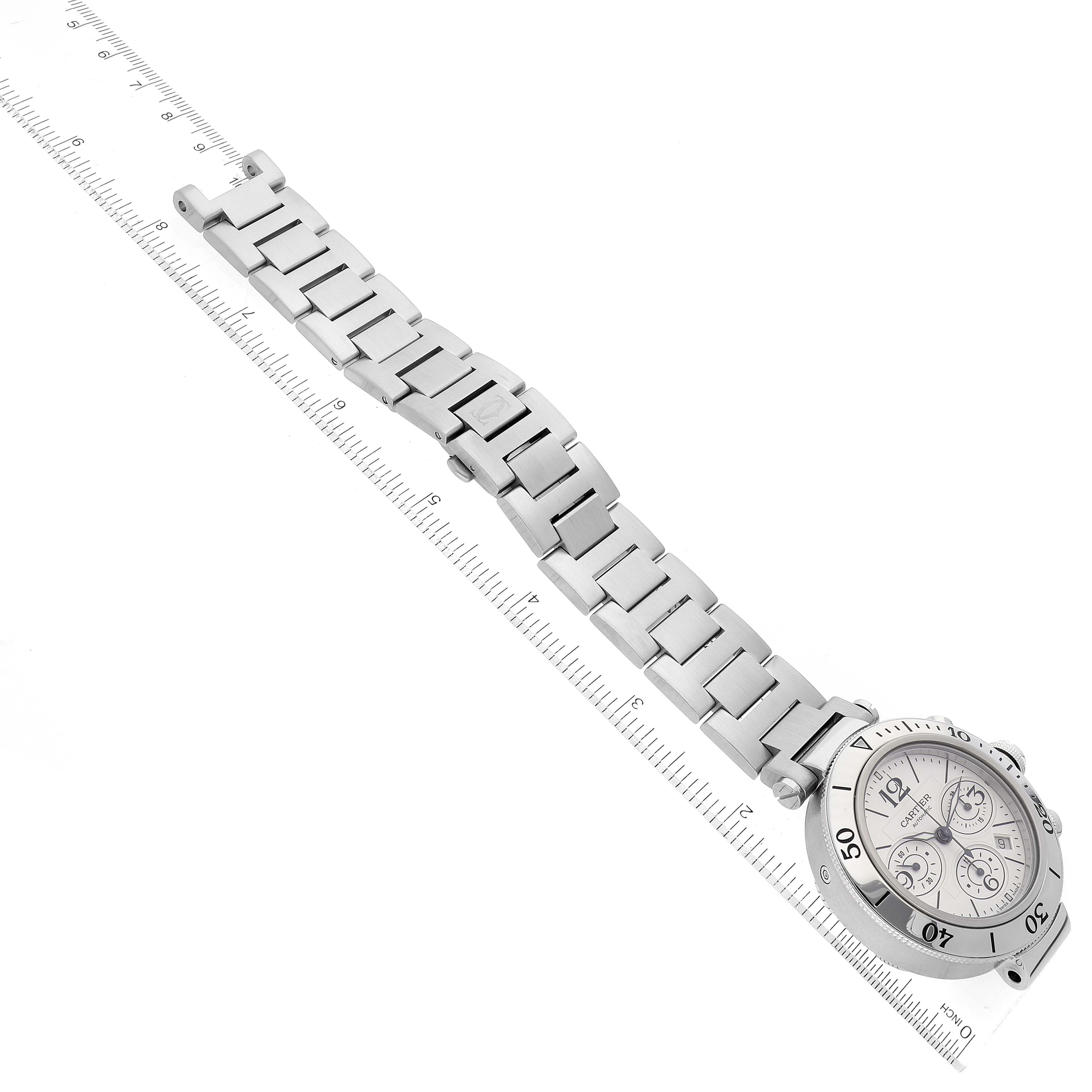 The image shows the Cartier Pasha W31089M7 Men's Stainless Steel Silver Dial W31089M7 Men's Stainless Steel Silver Dial watch from an angled top view, displaying the face and entire metal bracelet placed along a ruler.