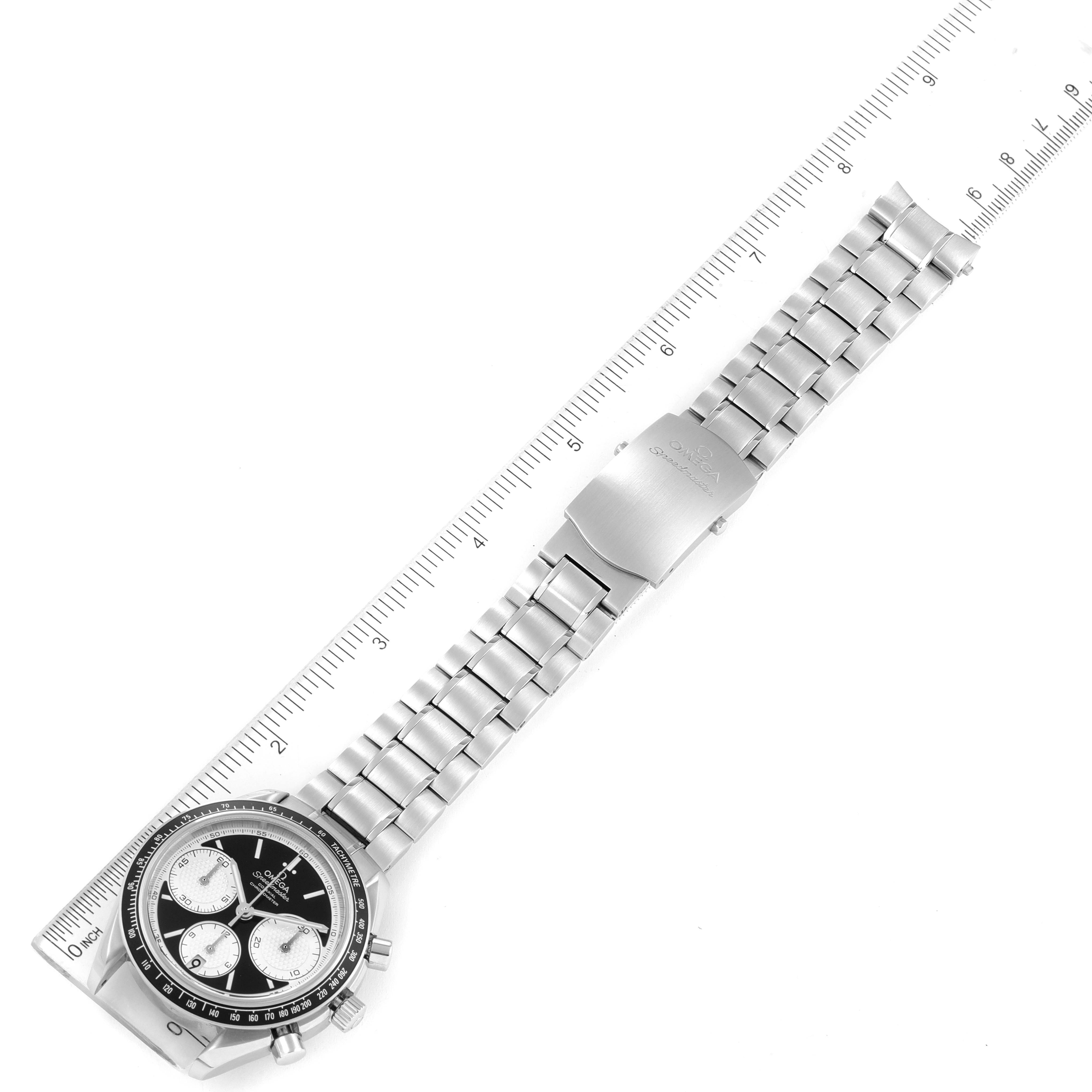 This image shows an Omega Speedmaster 326.30.40.50.01.002 Men
s Stainless Steel Black Dial 326.30.40.50.01.002 Men
s Stainless Steel Black Dial watch laid flat with a view of the entire band, clasp, and partially the face, next to a ruler.