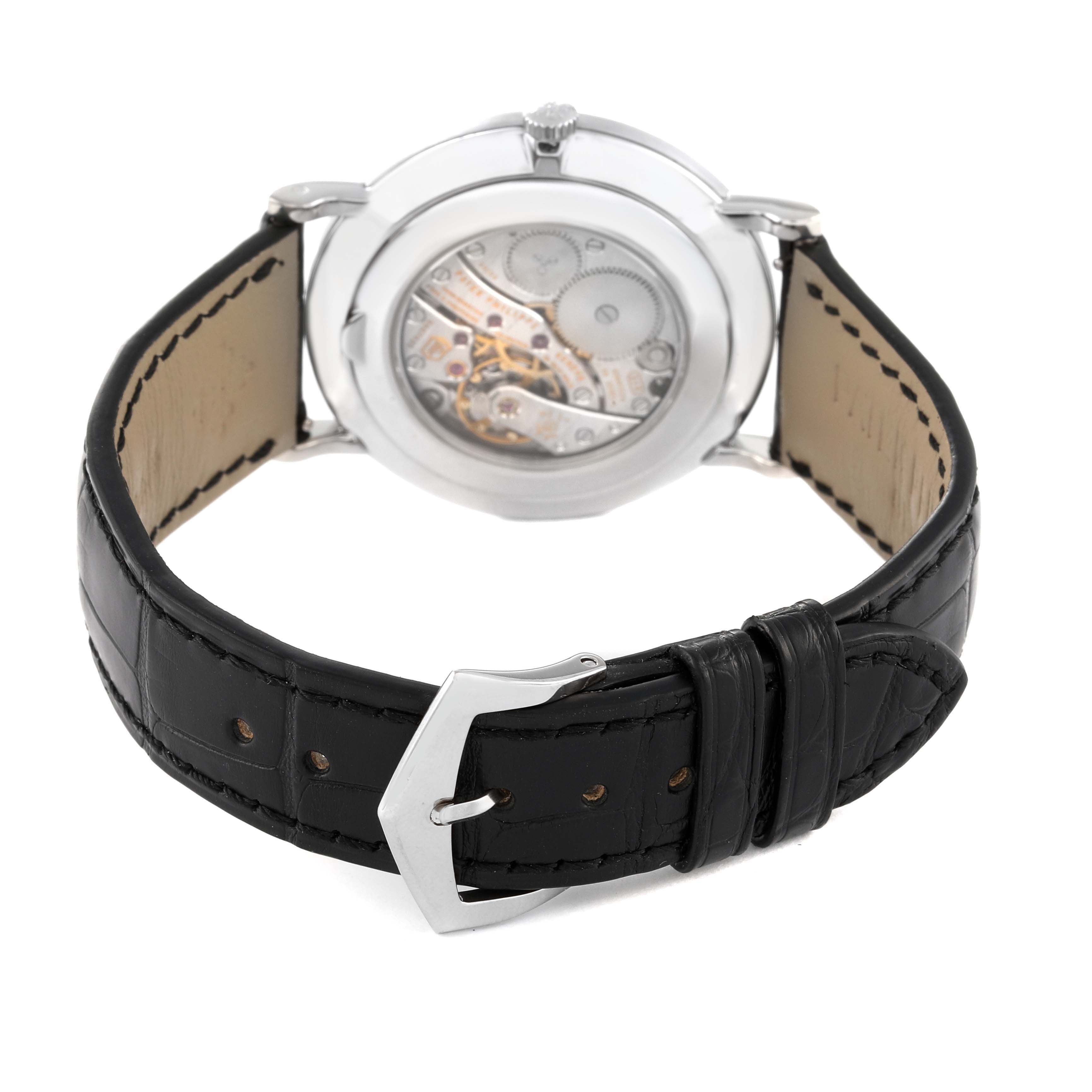 The image shows the back view of a Patek Philippe Calatrava 5119G Men
s White Gold White Dial 5119G Men
s White Gold White Dial watch, displaying the movement and the black leather strap with a buckle.