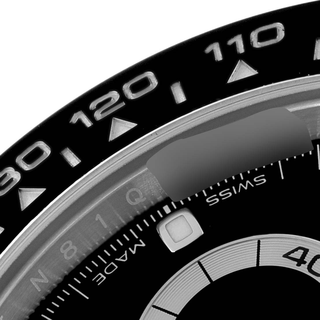This close-up image shows the bezel and part of the dial of a Rolex Daytona 116500 Men's Stainless Steel Black Dial 116500 Men's Stainless Steel Black Dial watch.