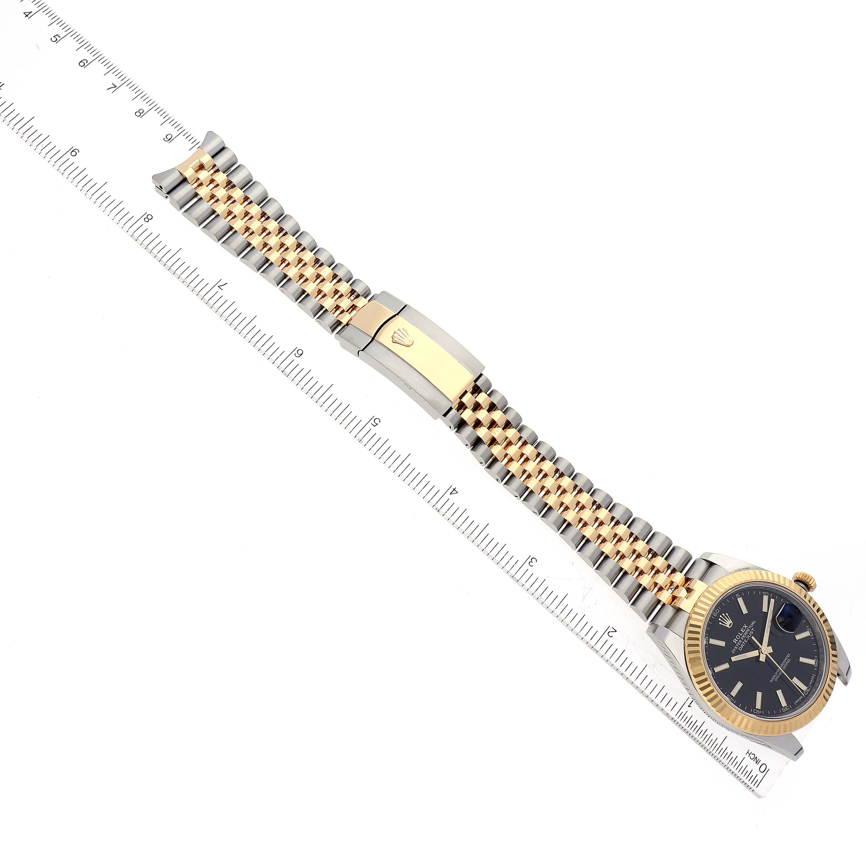 This image shows the Rolex Datejust 41 126333 Men's Steel and Gold (two tone) Black Dial 126333 Men's Steel and Gold (two tone) Black Dial watch with a gold and silver jubilee bracelet, captured from above alongside a ruler.
