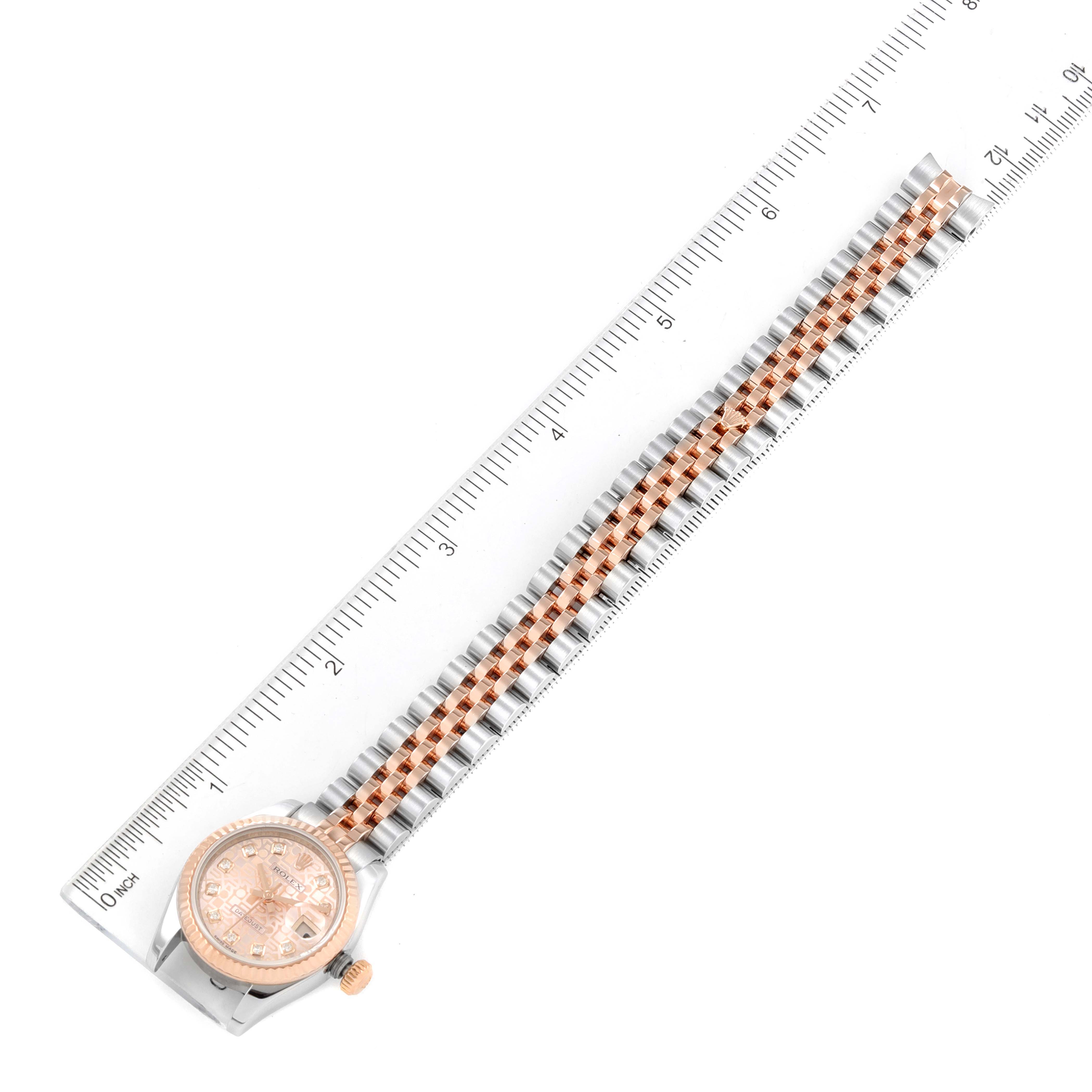 The image shows a Rolex Datejust 179171 Women's Steel and Gold (two tone) Pink Dial 179171 Women's Steel and Gold (two tone) Pink Dial watch laid flat from an overhead angle, including the face, bezel, and entire band beside a ruler.