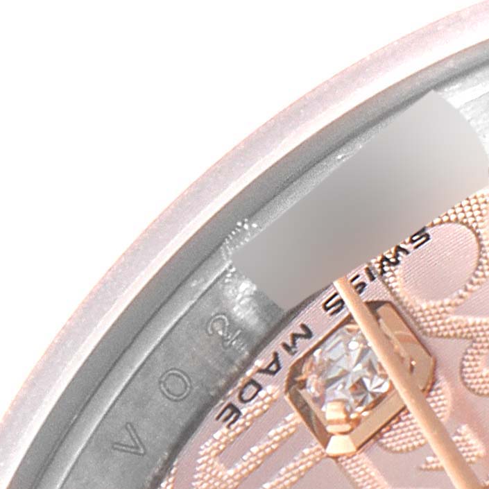 Close-up of the dial and a portion of the bezel of a Rolex Datejust 179171 Women's Steel and Gold (two tone) Pink Dial 179171 Women's Steel and Gold (two tone) Pink Dial watch, showing part of the "SWISS MADE" text and a diamond marker.