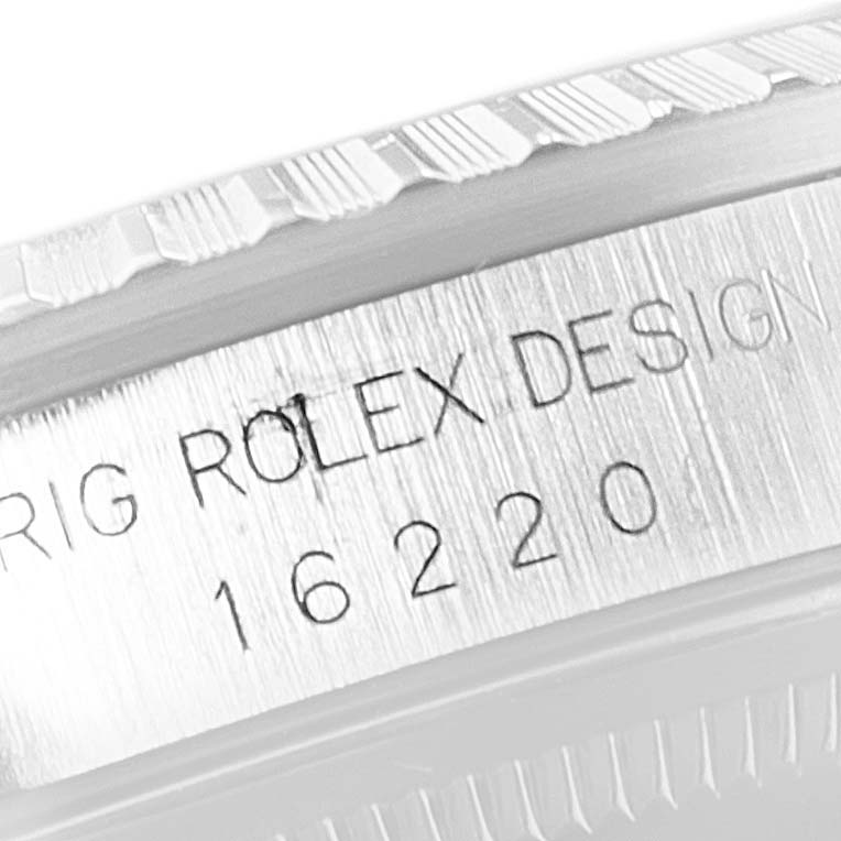 The image shows a close-up of the engraved serial number and design text on the side of a Rolex Datejust 16220 Men's Stainless Steel Silver Dial 16220 Men's Stainless Steel Silver Dial model 16220 case.