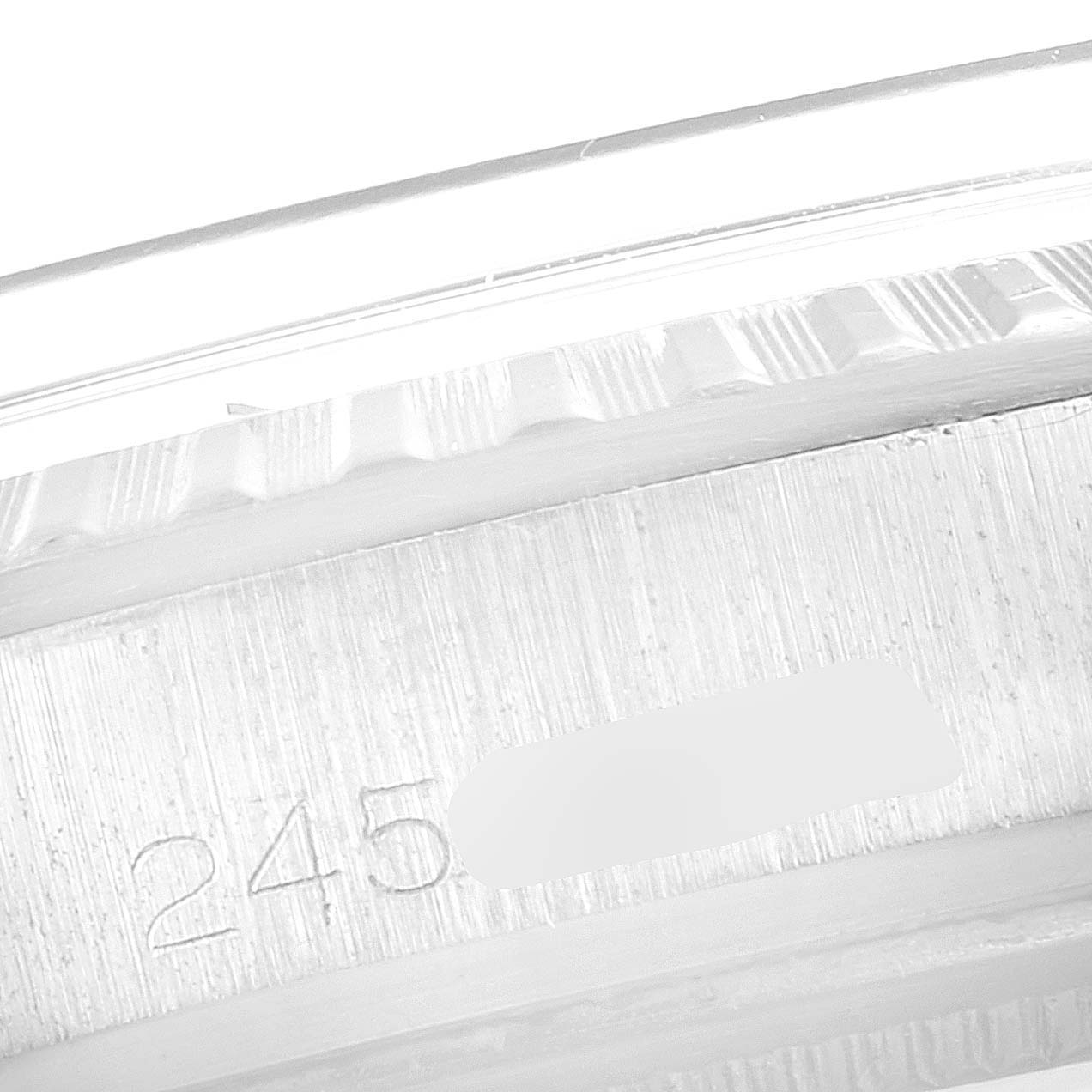 This image shows a close-up of the engraved serial number on the side of the case of a Vintage Collection model Rolex watch.