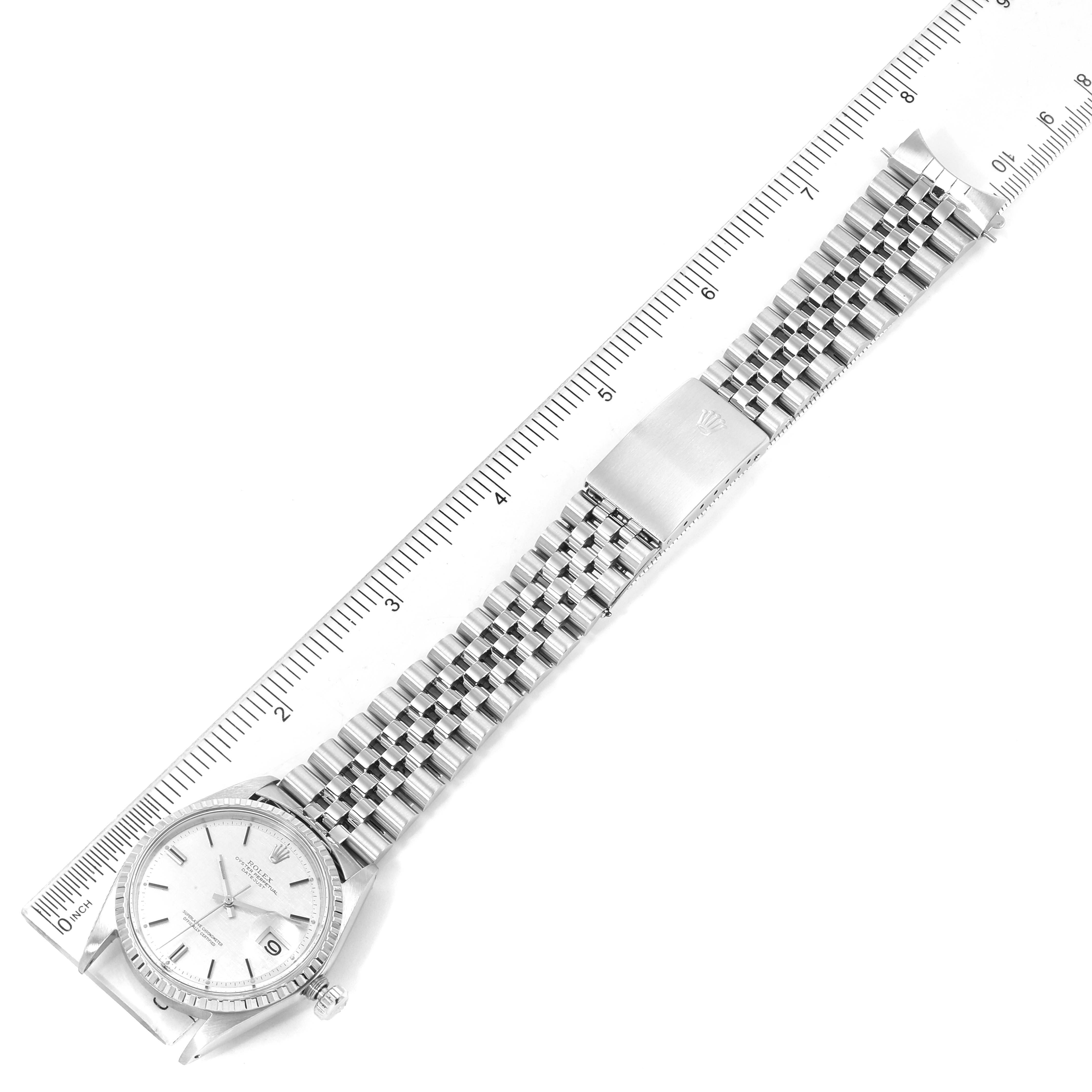 The image shows a full view of a Rolex Vintage Collection 1603 Men's Stainless Steel Silver Dial 1603 Men's Stainless Steel Silver Dial watch aligned with a ruler, showcasing the watch face, bracelet, and clasp.