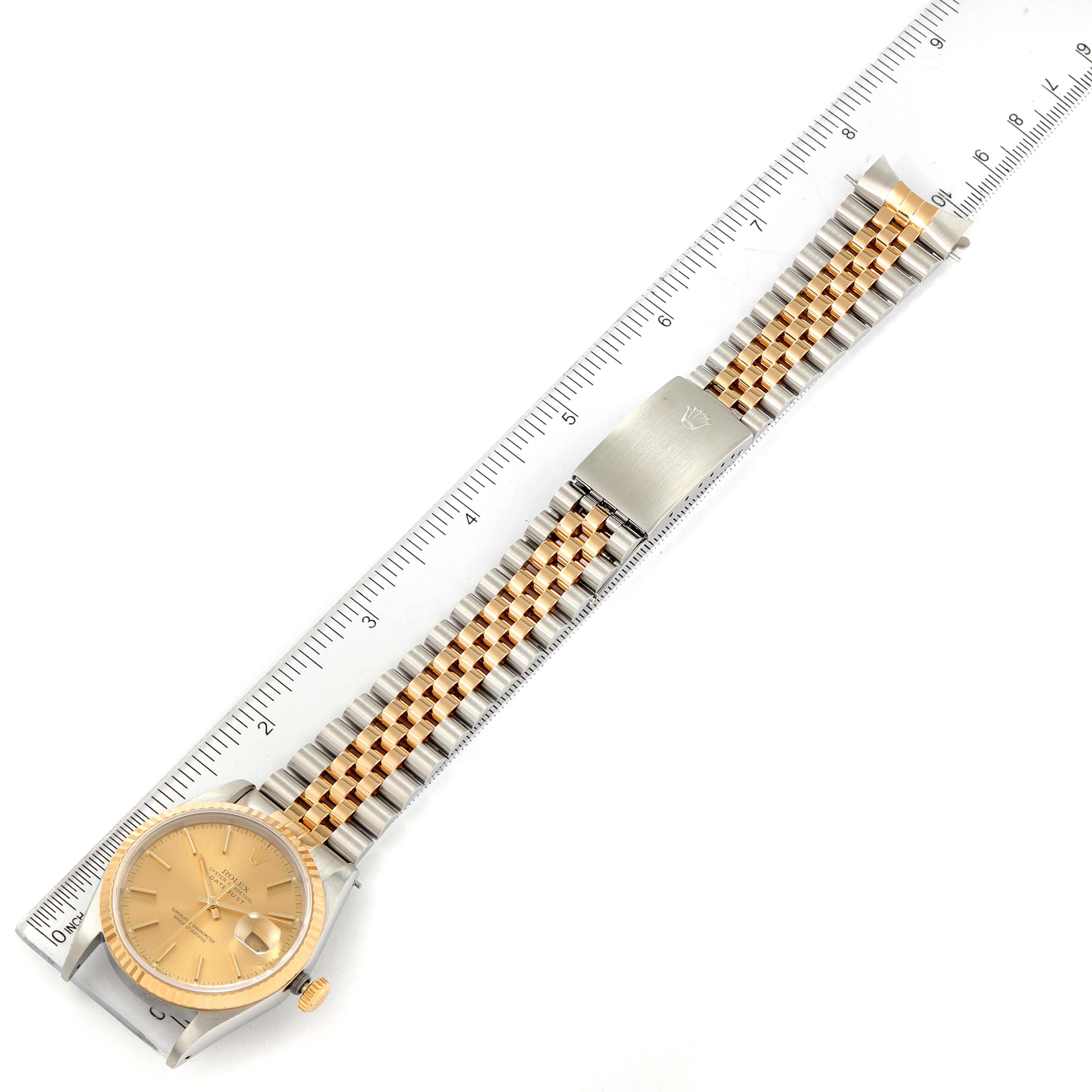 The image shows a Rolex Datejust 16233 Men's Steel and Gold (two tone) Champagne Dial 16233 Men's Steel and Gold (two tone) Champagne Dial watch laid flat with its bracelet extended alongside a ruler for measurement.