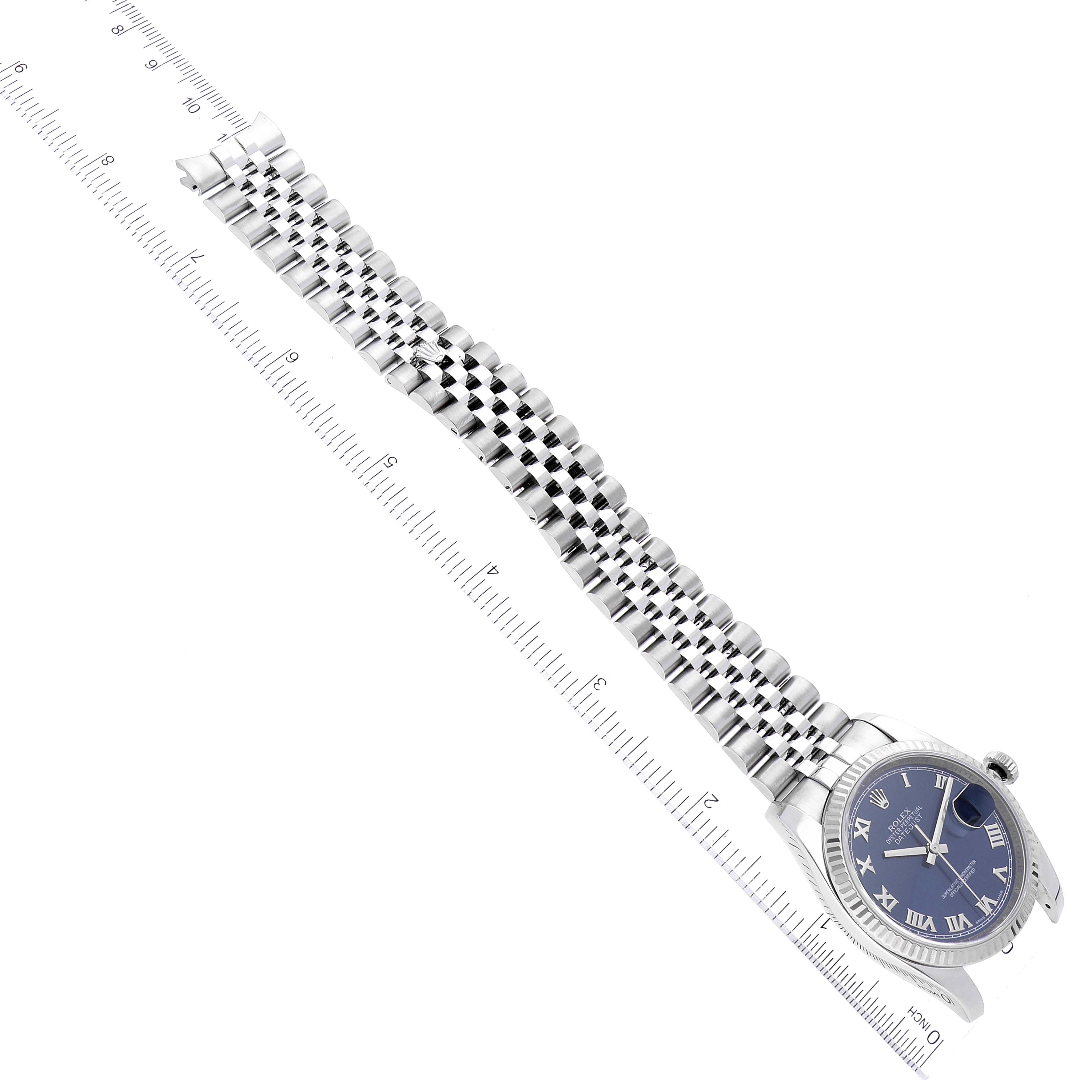 The image shows the Rolex Datejust 116234 Men's Stainless Steel Blue Dial 116234 Men's Stainless Steel Blue Dial watch from a top-down angle, highlighting the face and the full length of the metal bracelet alongside a ruler.
