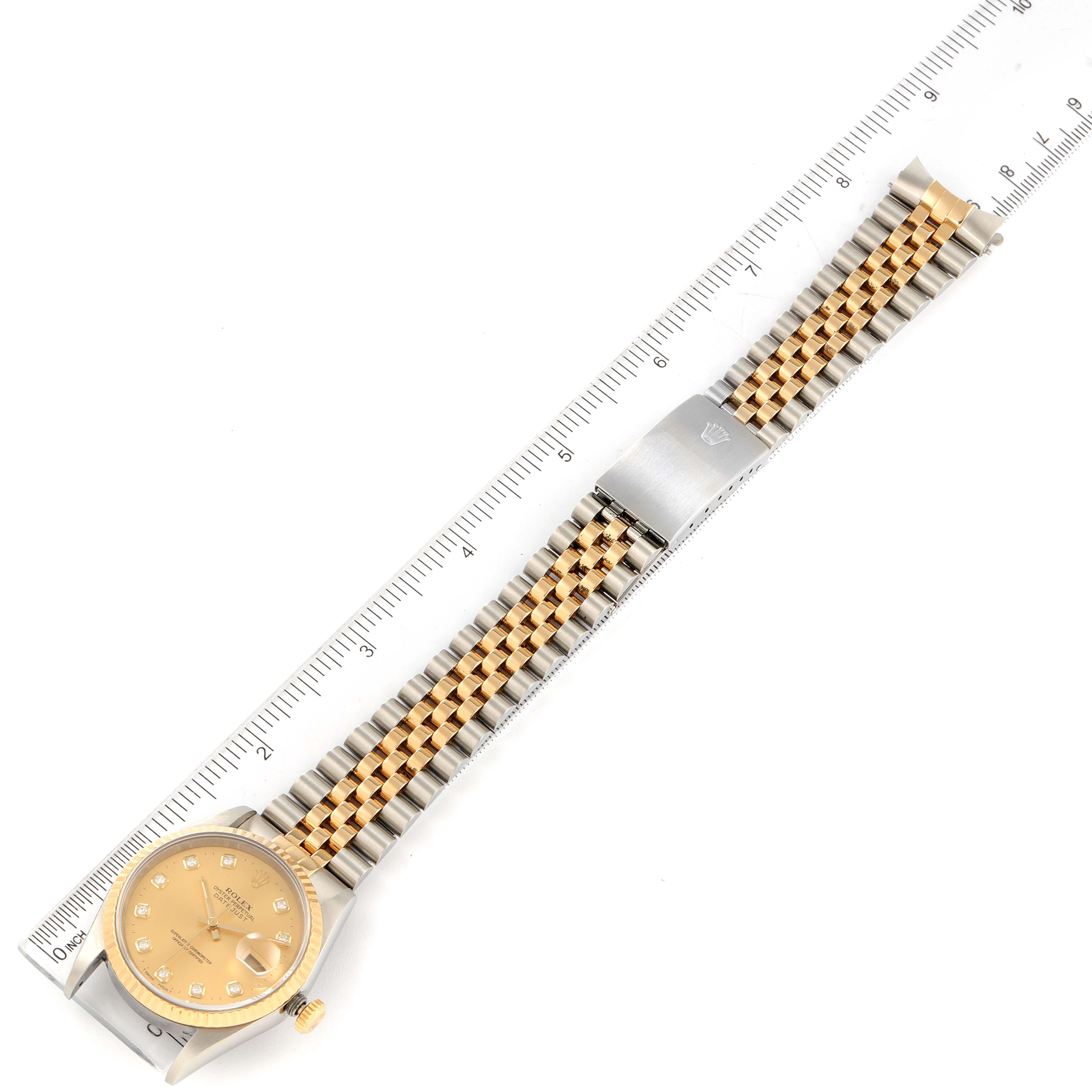 The image shows a Rolex Datejust 16233 Men's Steel and Gold (two tone) Champagne Dial 16233 Men's Steel and Gold (two tone) Champagne Dial model watch laid flat next to a ruler, displaying the face, bracelet, and clasp.