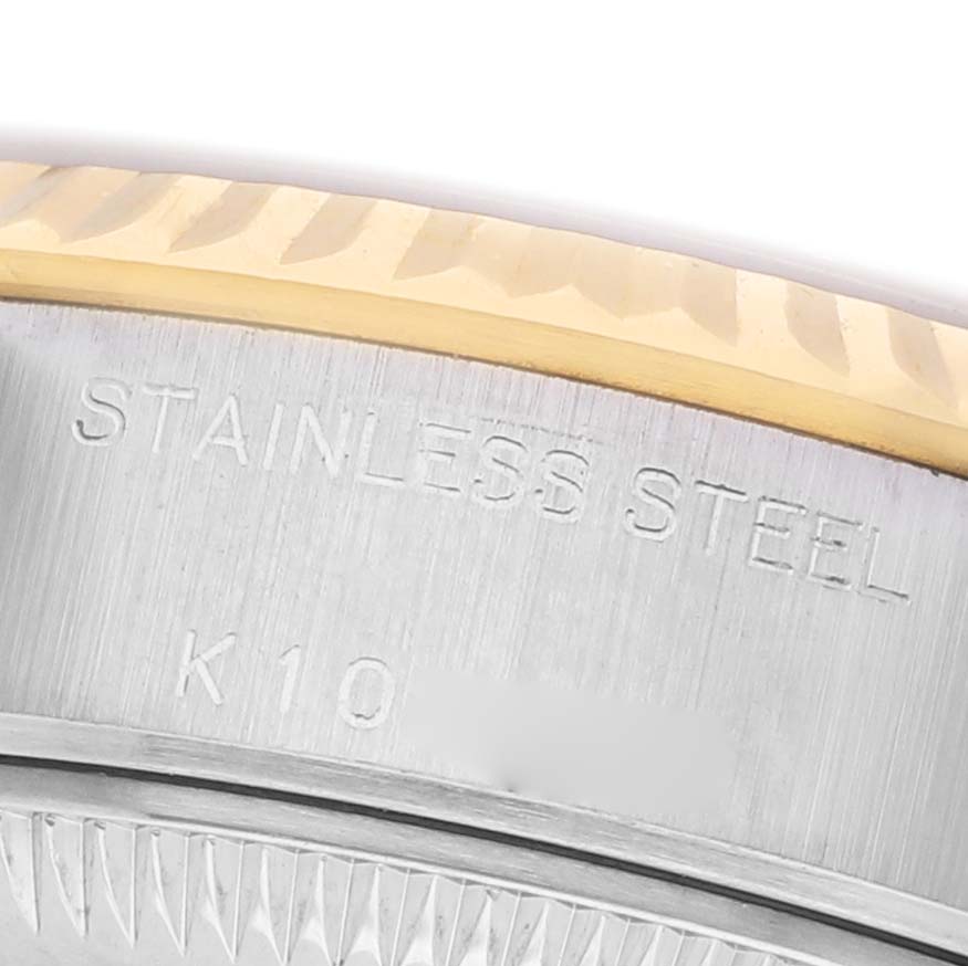 The image shows a close-up angle of the side of a Rolex Datejust 79173 Women's Steel and Gold (two tone) White Dial watch, featuring the engraved "STAINLESS STEEL" text on the case edge.